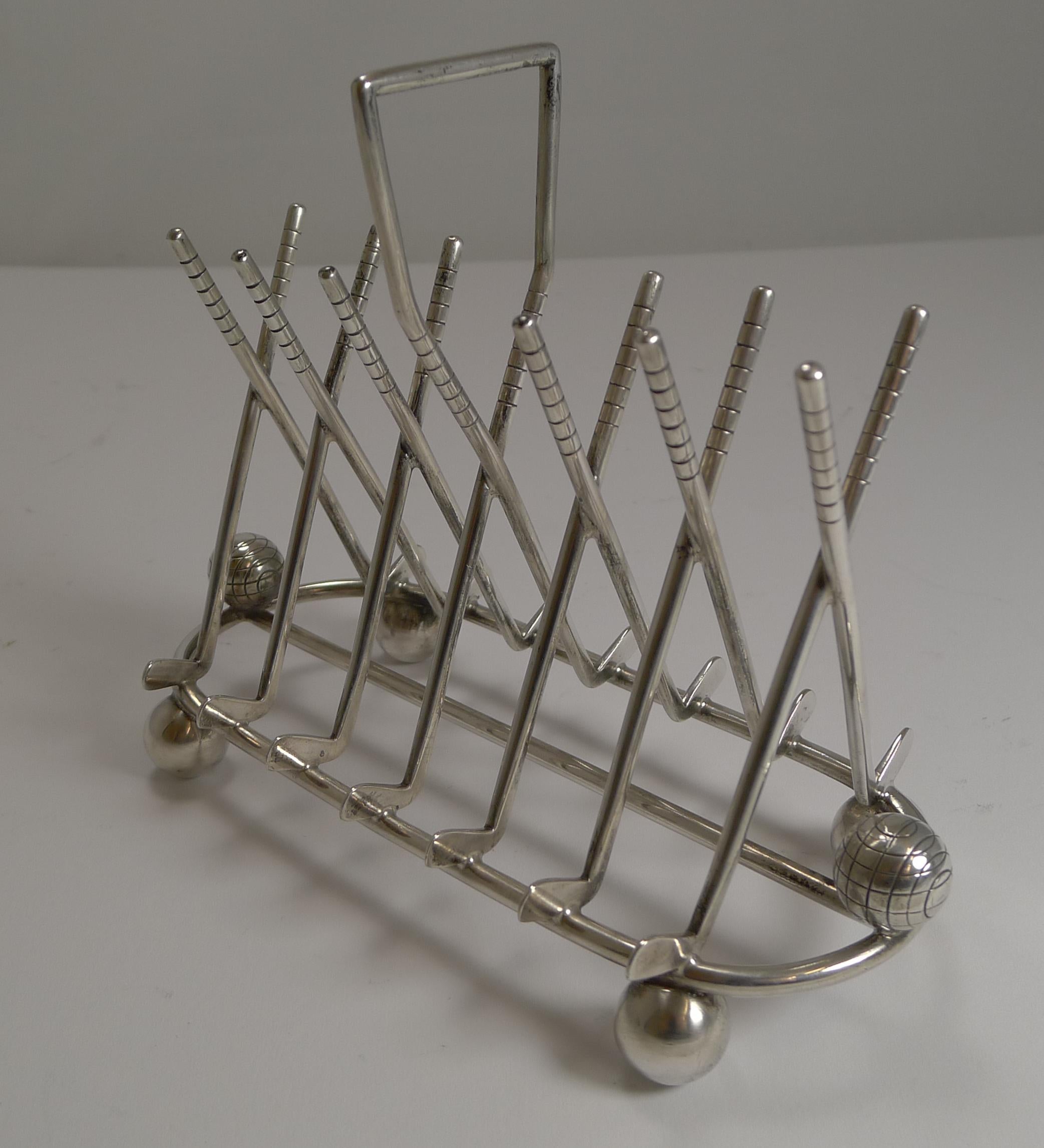 A highly collectible antique English figural toast rack made up of Golf Clubs creating the divisions, today as popular desk-top as a letter holder. 
Either end of the base there is a mounted golf ball.

Dating to around 1900, there is no makers