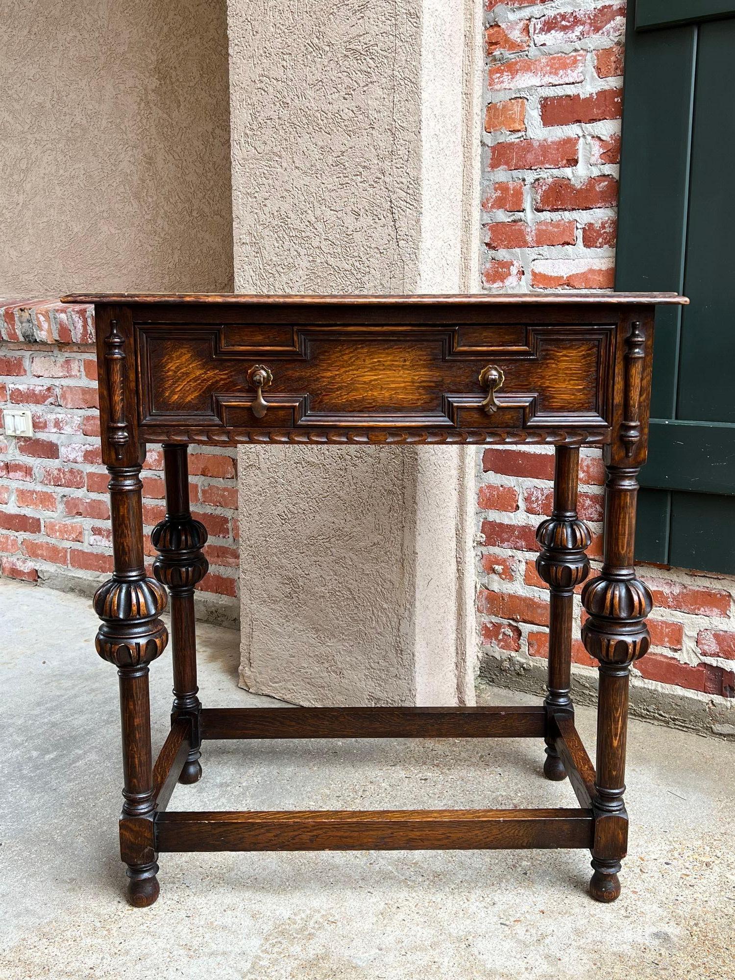 Antique English hall sofa table Jacobean carved oak c1920.

Direct from England, a charming British sofa or hall table. Classic Jacobean style with a geometric paneled wide front drawer and original brass drop drawer pulls. Jacobean trim to either