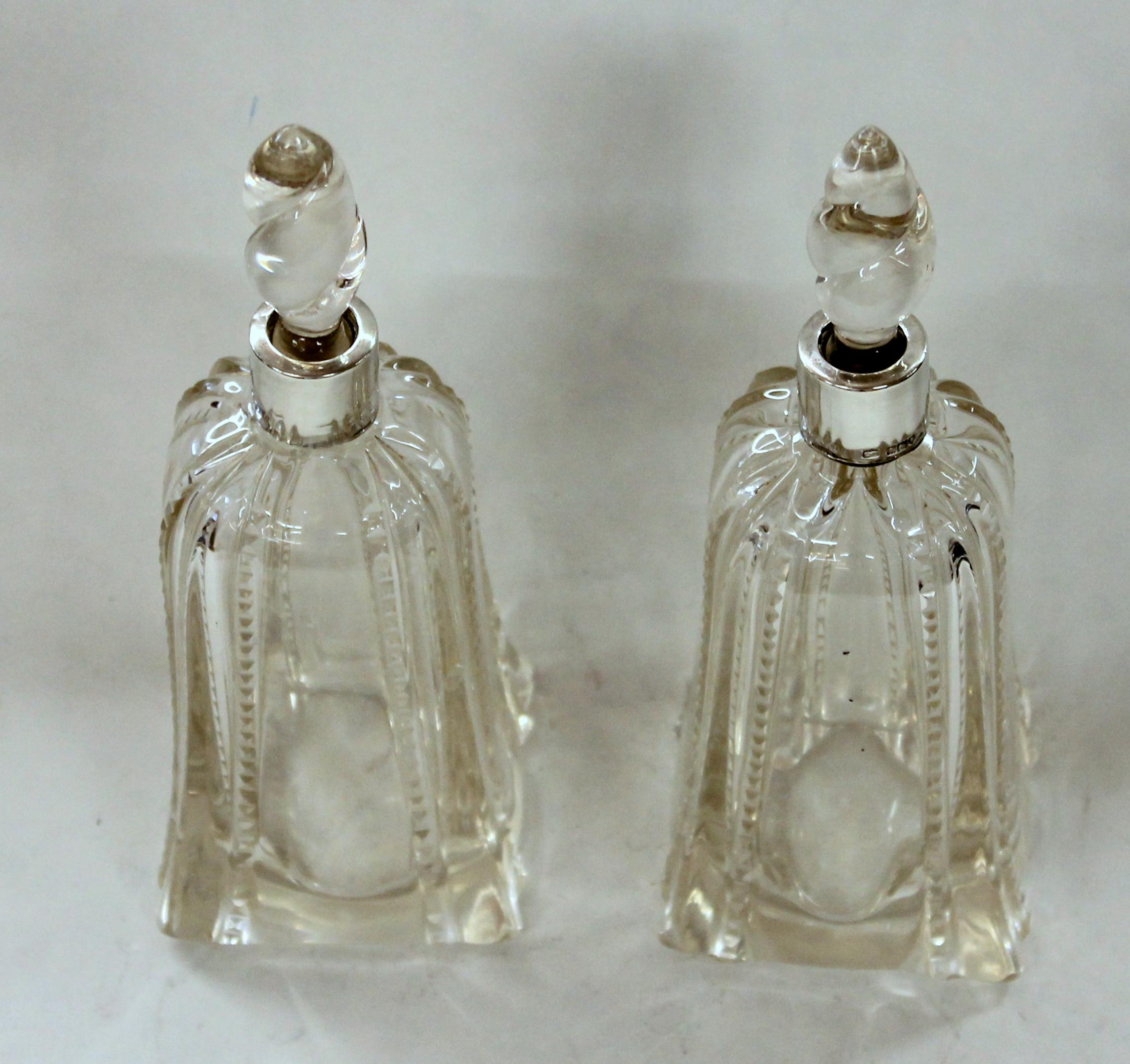 Antique English hallmarked sterling collared and hand-cut crystal scent or perfume bottles.
Hallmarks visible but worn and illegible. Warranted English hallmarked sterling collars and English cut crystal. Superb spiral shaped stoppers.
 