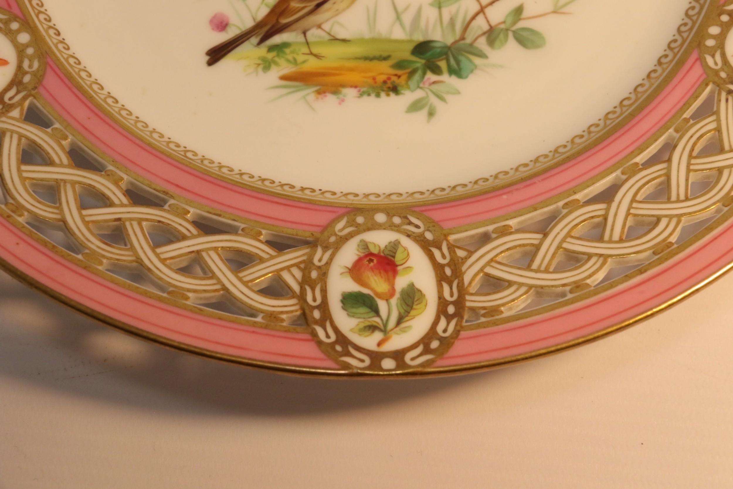 This beautiful English porcelain cabinet plate was made at the Minton factory circa 1863.
This fine quality piece has a hand painted centre decorated with birds on a leafy branch and a pierced and gilded border with six oval panels with various