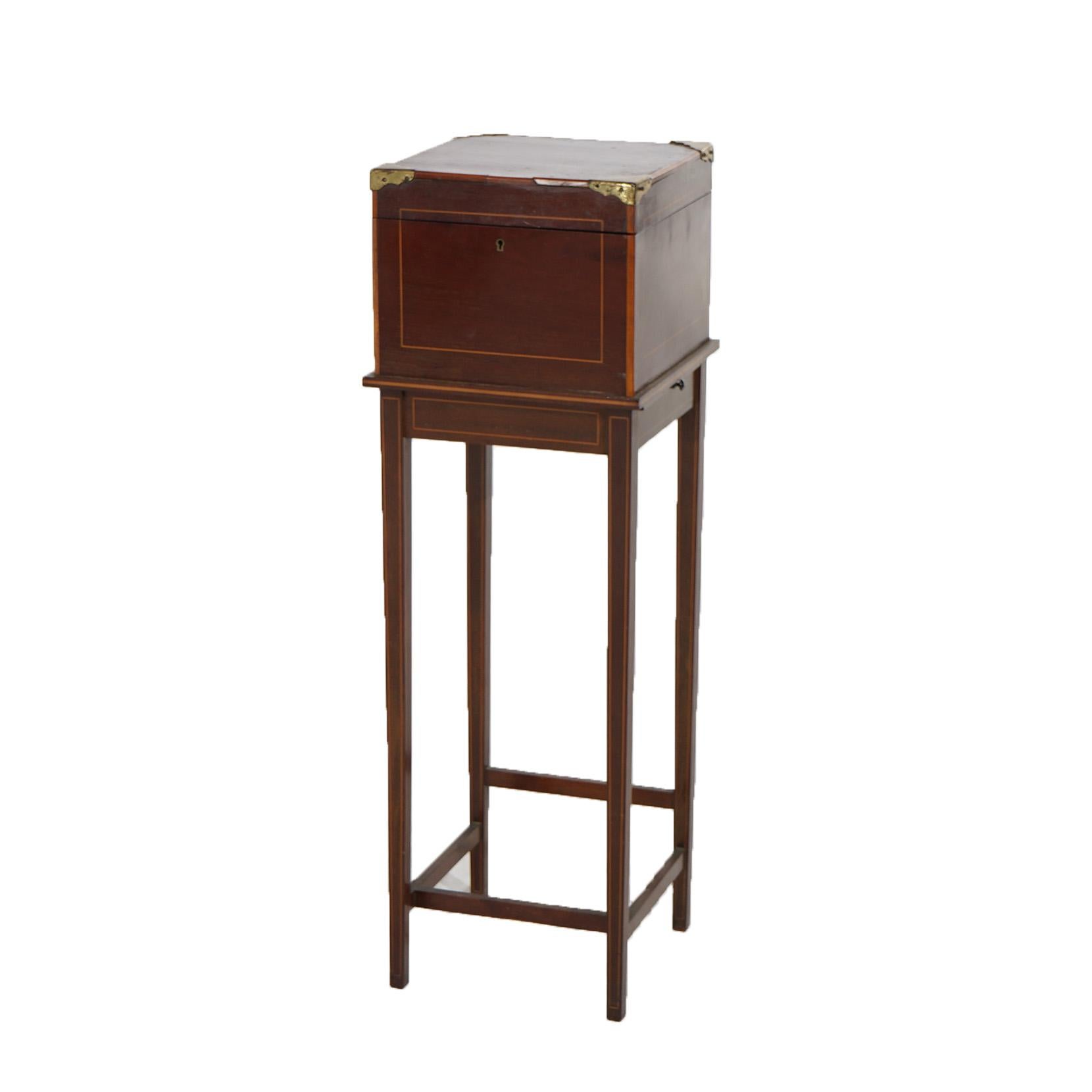 ***Ask About Discounted In-House Shipping***
An antique English Hepplewhite sewing stand offers satinwood banded mahogany construction with lift-top and drop-front opening to reveal two drawers, raised on straight and tapered legs, brass caps