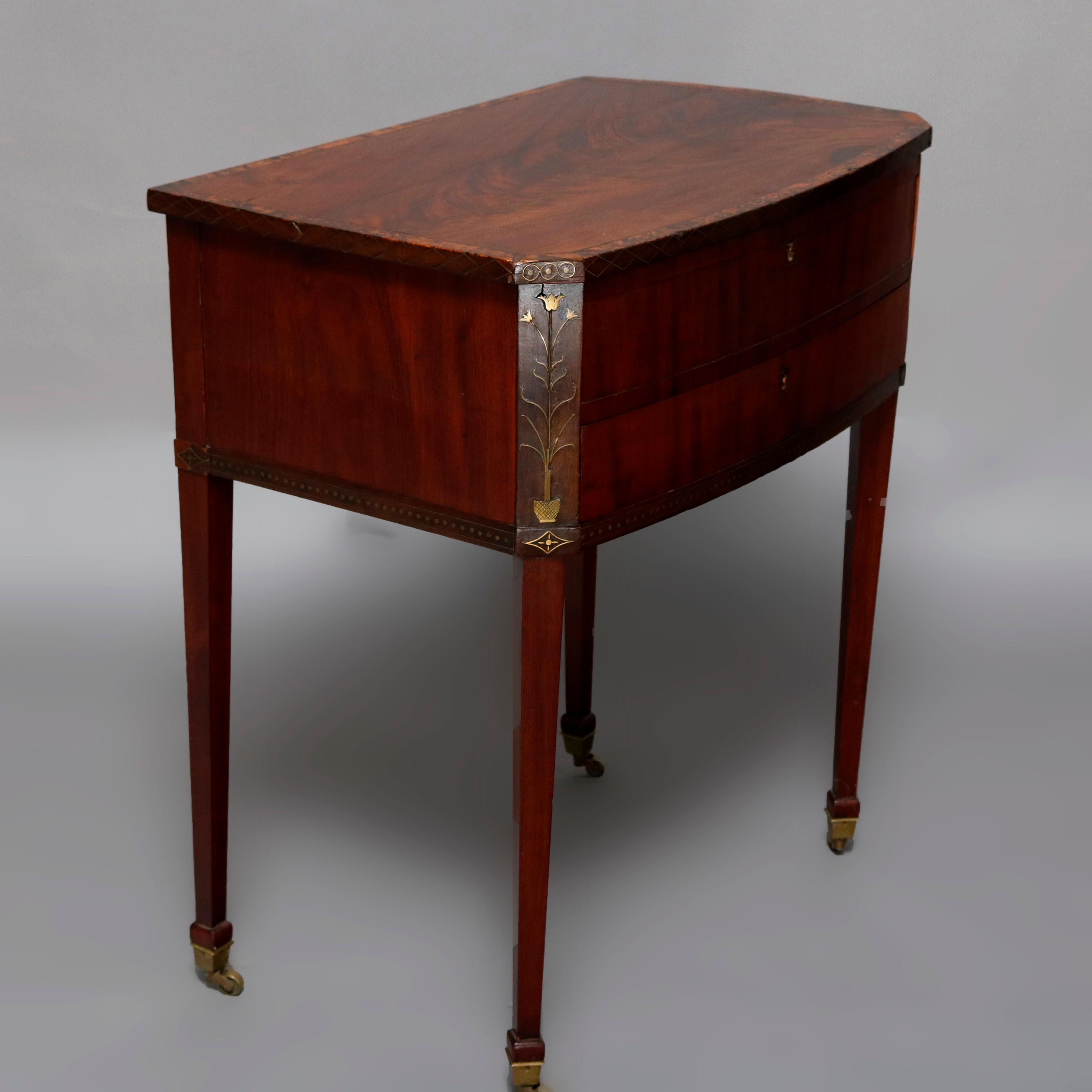 An antique English Hepplewhite sewing stand offers flame mahogany with cross banded lid lifting to reveal interior compartments, clipped corners of the case with satinwood marquetry inlaid potted flowers, satinwood banding inside lid and inlay trim