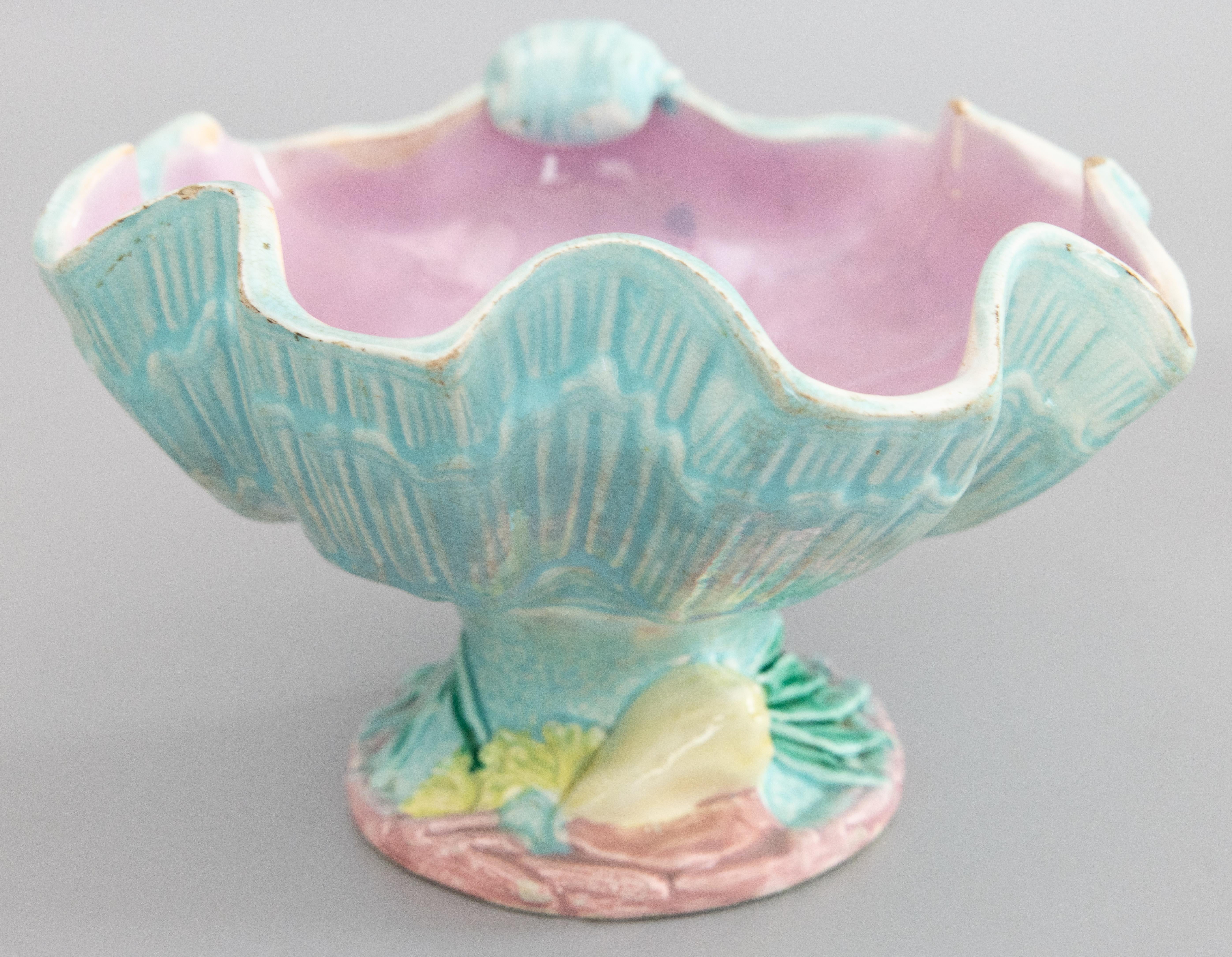 A lovely antique Victorian English majolica shell compote pedestal centerpiece by Joseph Holdcroft, circa 1880. The shell exterior is a turquoise blue in the shape of a giant clam, with a mulberry pink interior. The bowl sits on a 2