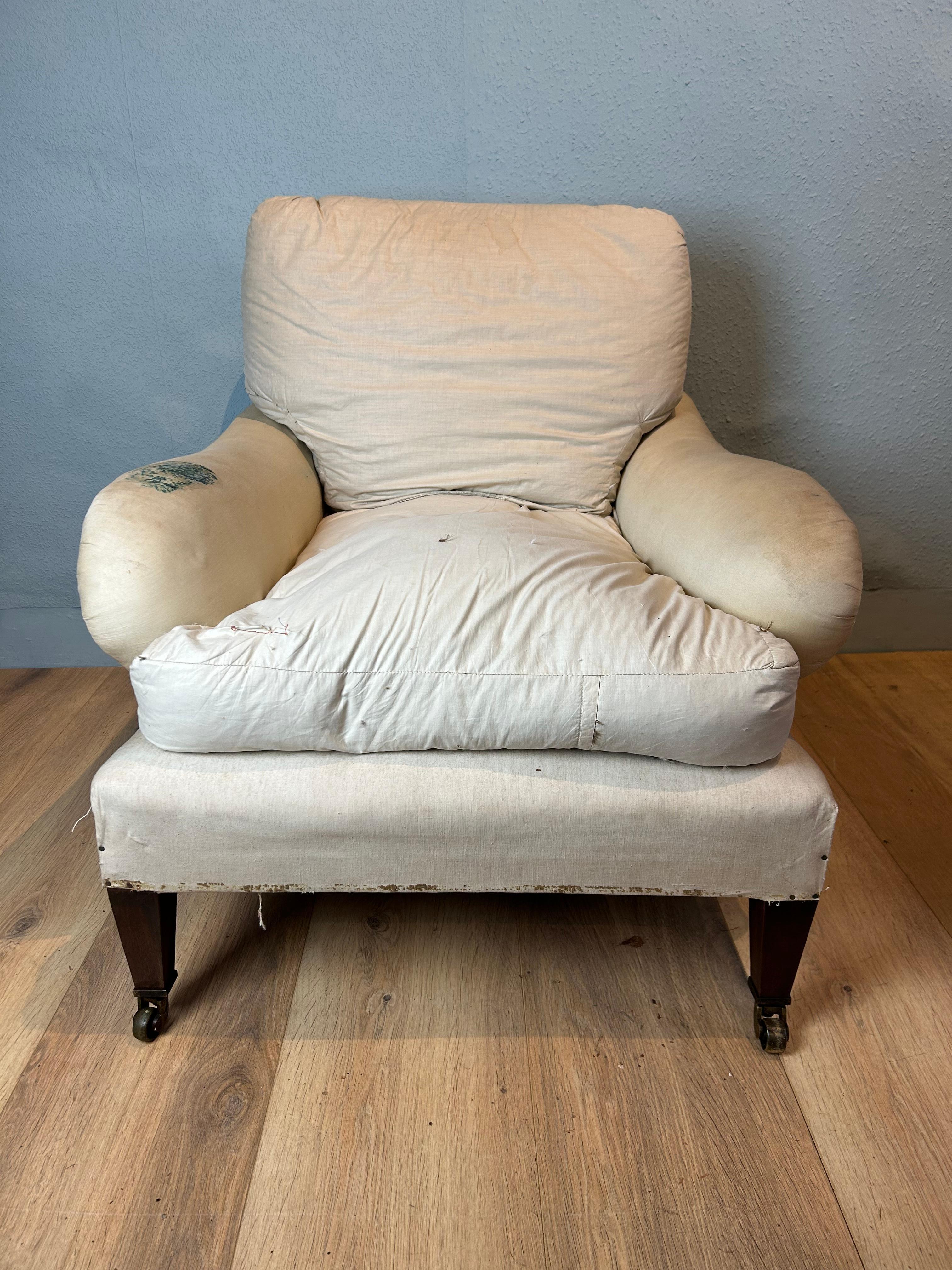 Antique Howard Bridgewater style upholstered arm chair circa 1890, retaining its original upholstery in the calico with feather and down seat and rear cushions, sitting on square tapered front legs, resting on brass plate castors. Seat height 15