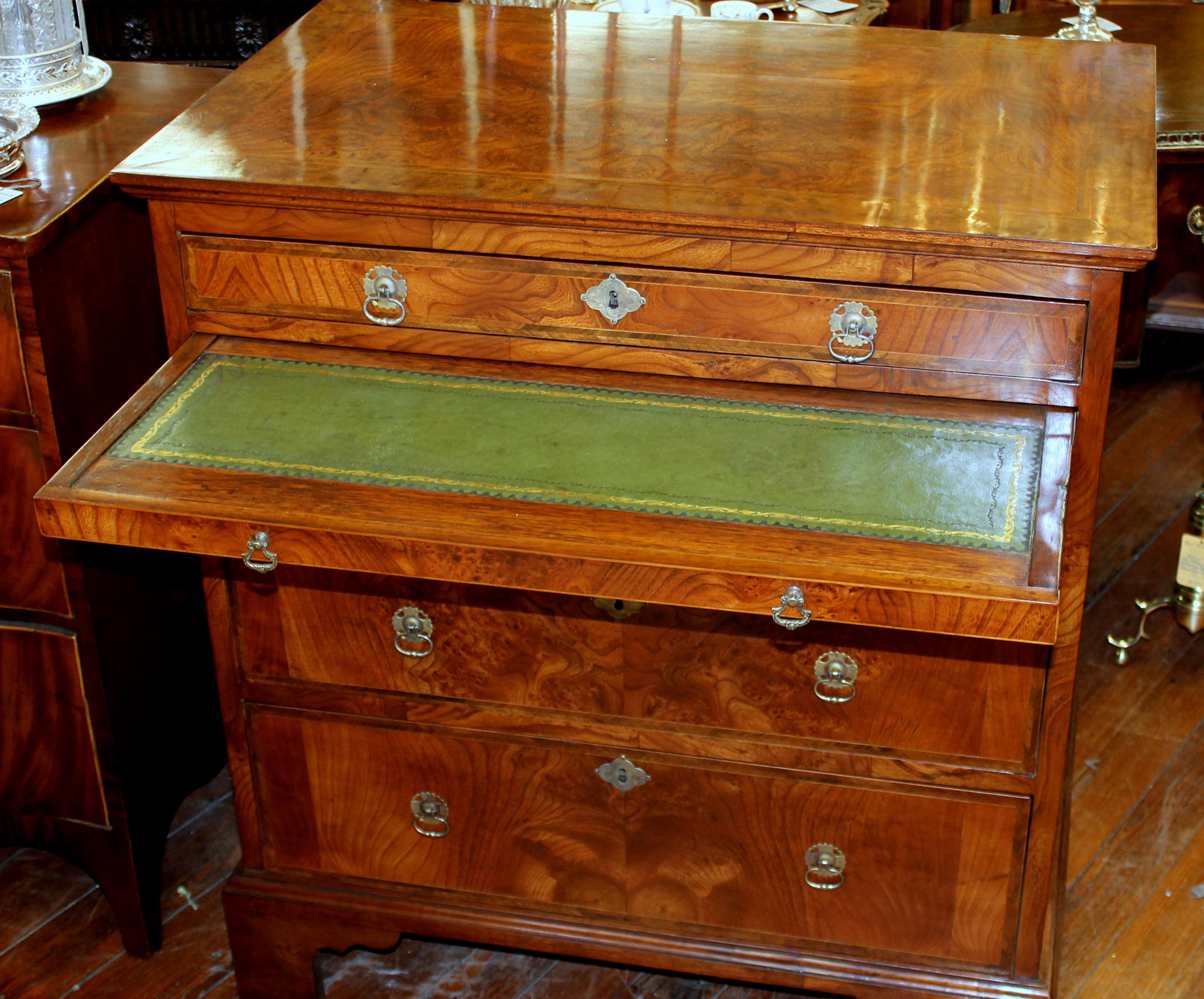 Fabulous and rare antique English inlaid burr elm Queen Anne style chest of drawers with brushing/writing slide. This is an antique made during the Queen Anne Revival period of the early 19th century from a design prevalent during the early 18th