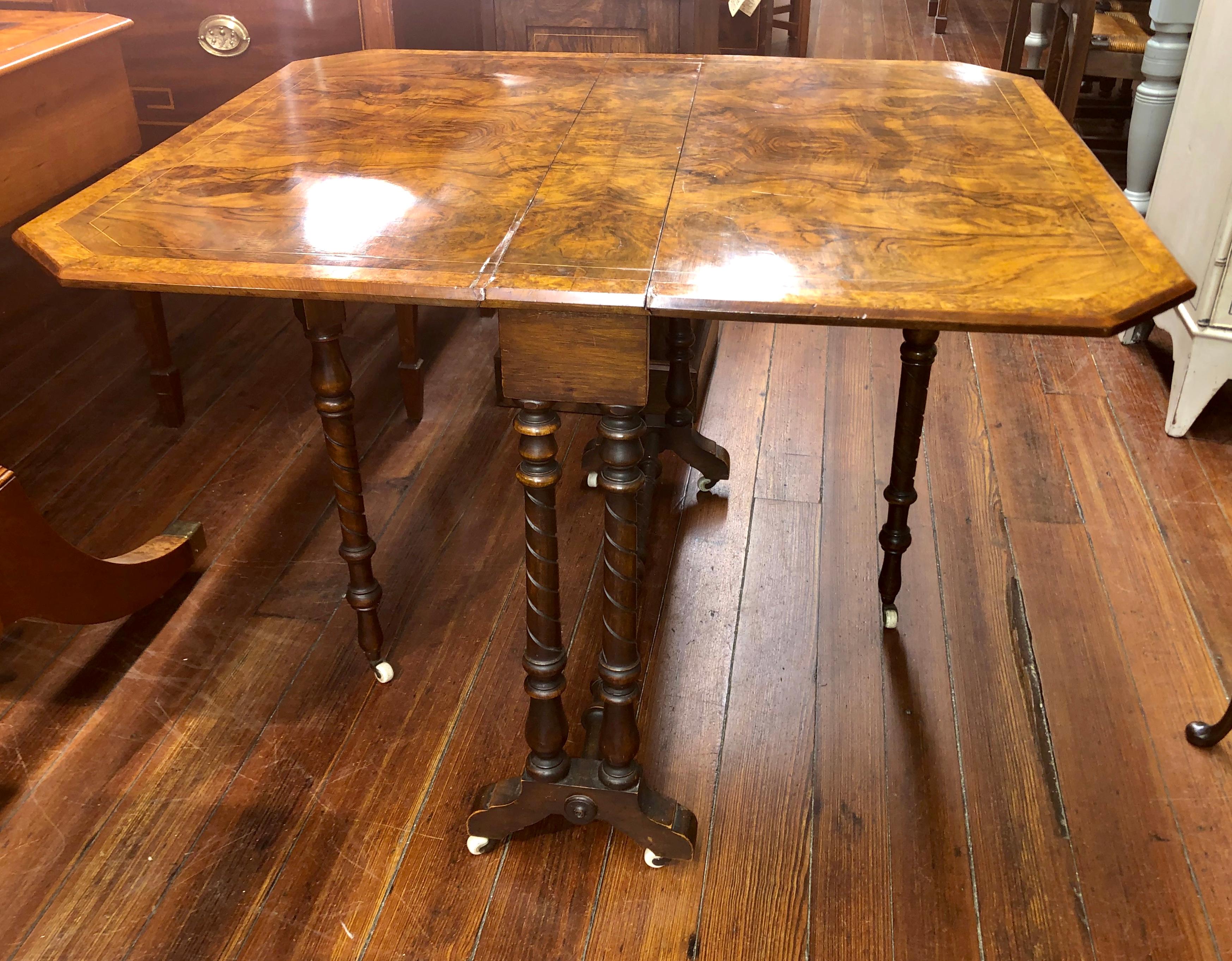 Exceptional highly figured inlaid burr walnut drop-leaf Sutherland table with gate legs on original casters. These tables are extremely versatile because they can be used completely closed where they are very narrow (6