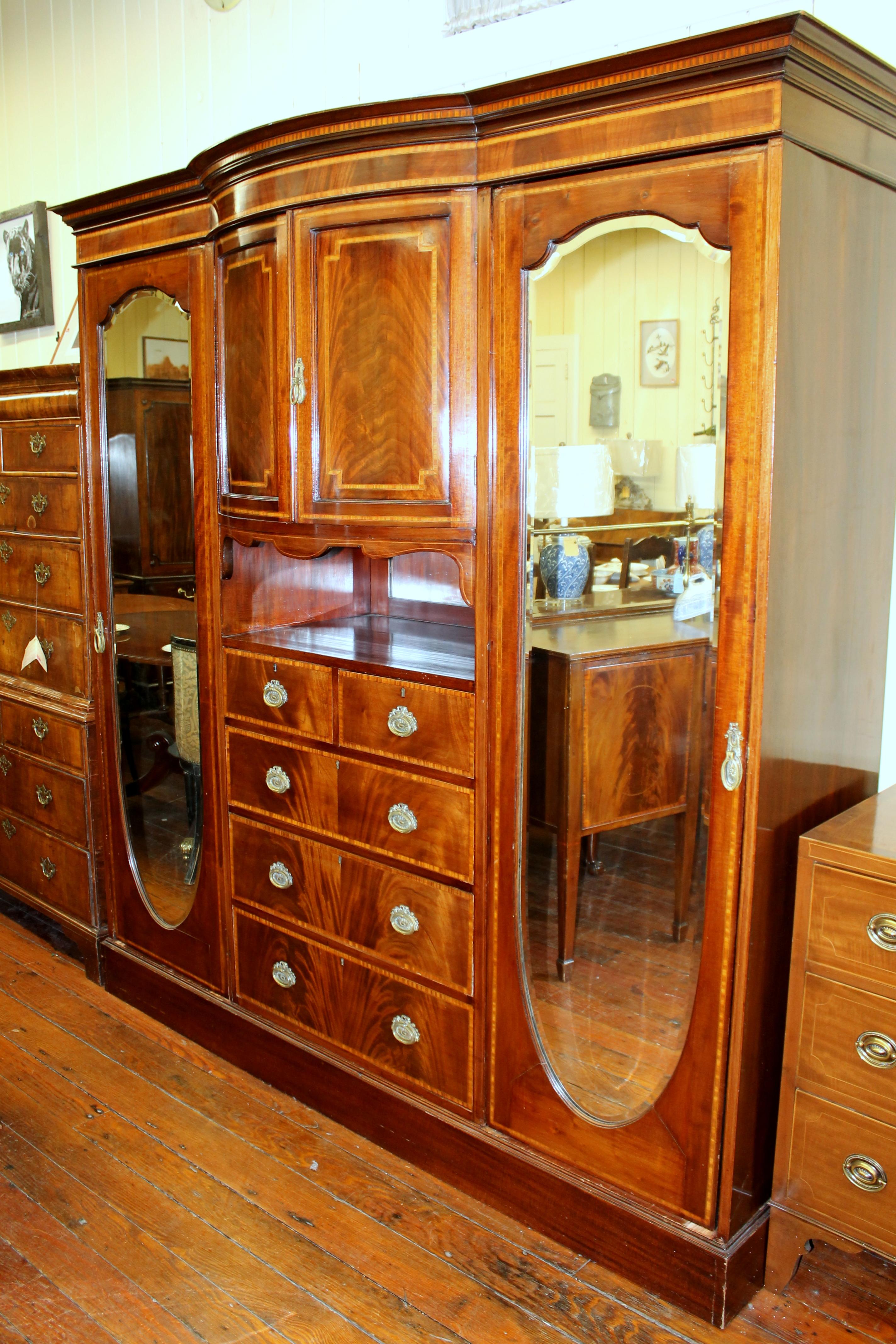 Fabulous quality antique English inlaid flame mahogany Edwardian period Compactum wardrobe with fabulous fitted interior and original mirrored doors. Also has rare 