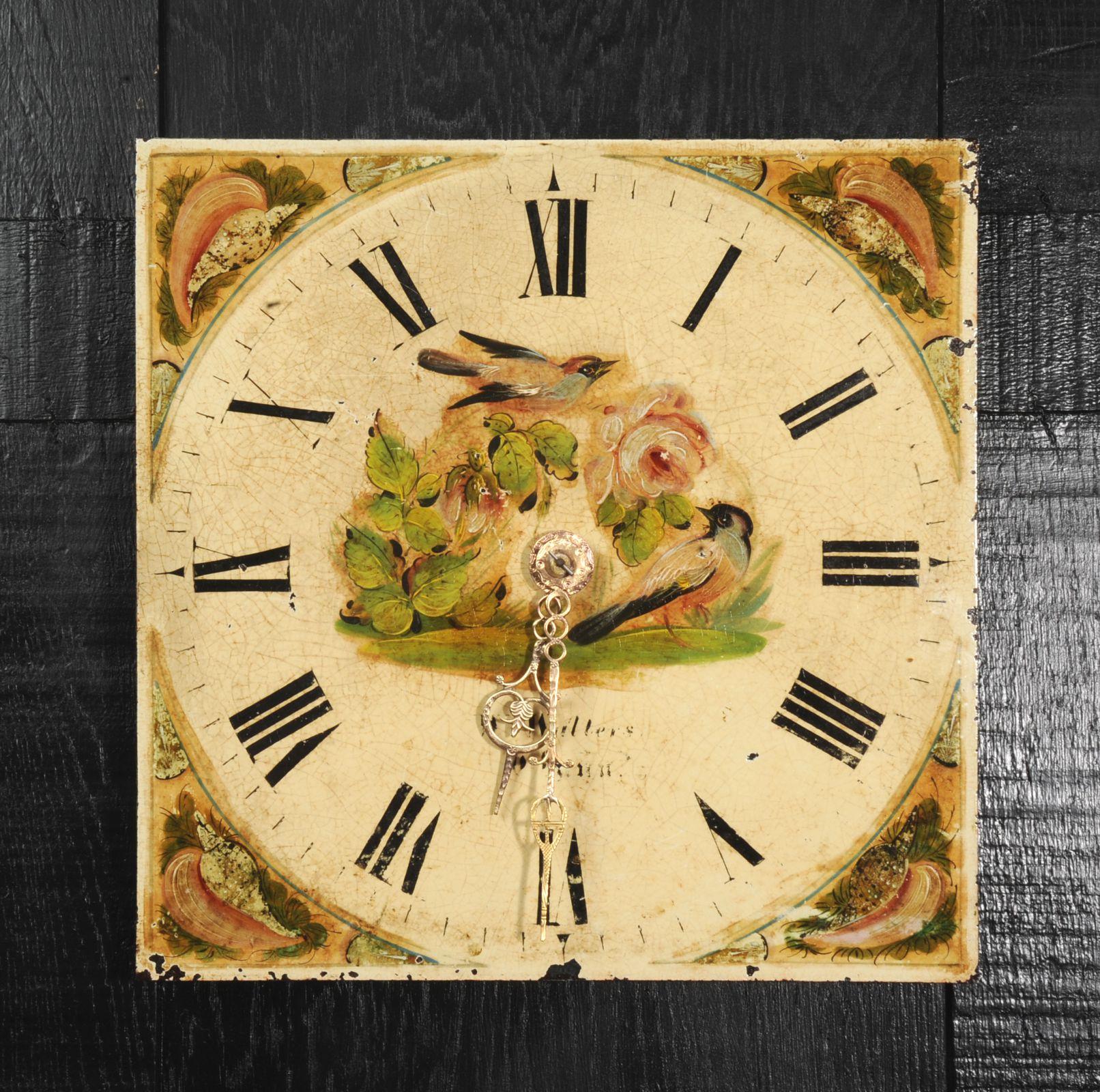 A lovely antique iron clock dial circa 1830 in its original enamel, charmingly decorated with birds and flowers. To the corners are charmingly painted shell motifs. With ancient craquelure, marks of a long life and its original handcut brass hands,