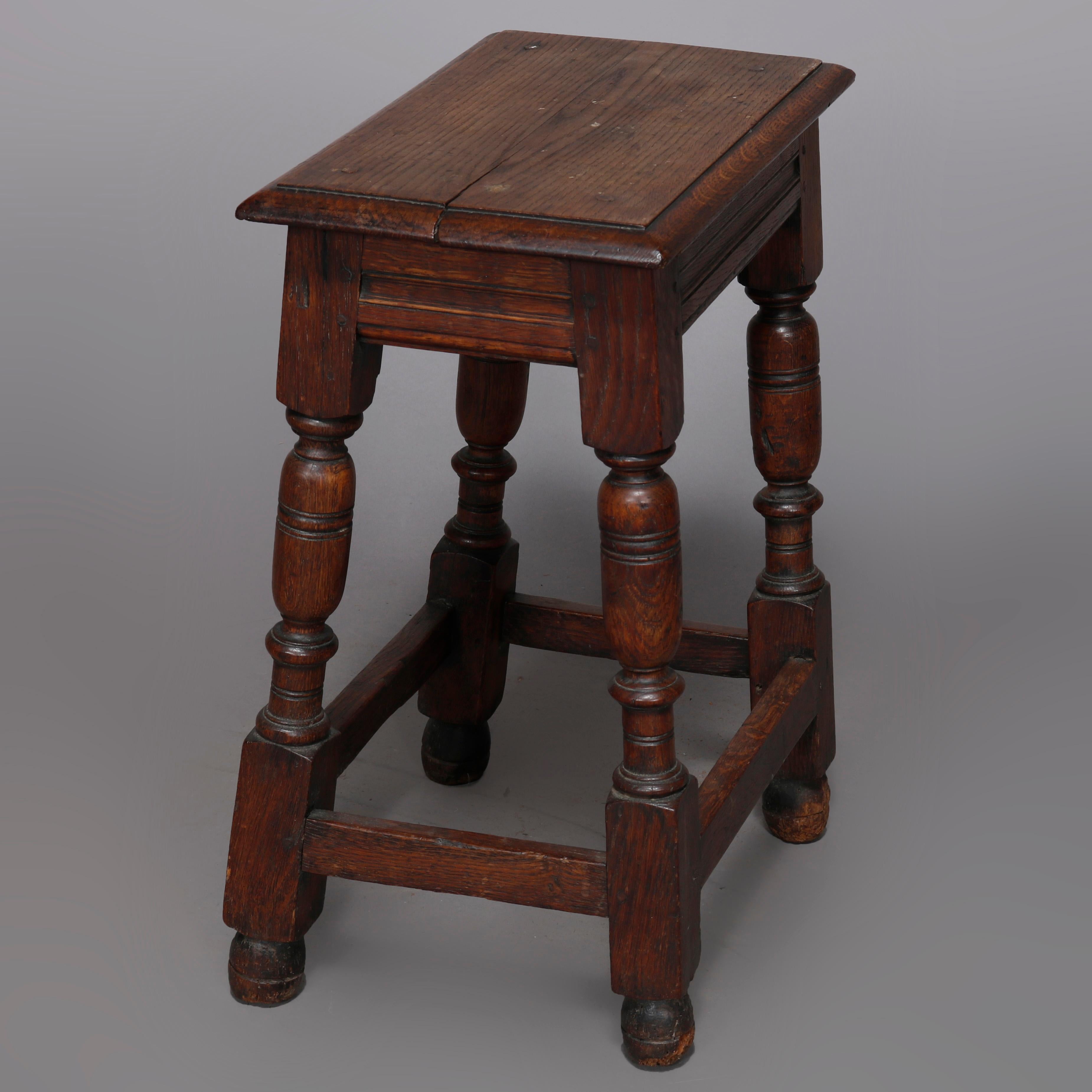 An antique English Jacobean stand or stool offers oak construction with beveled top surmounting balustrade legs with box stretcher, 18th century.

Measures: 22.5