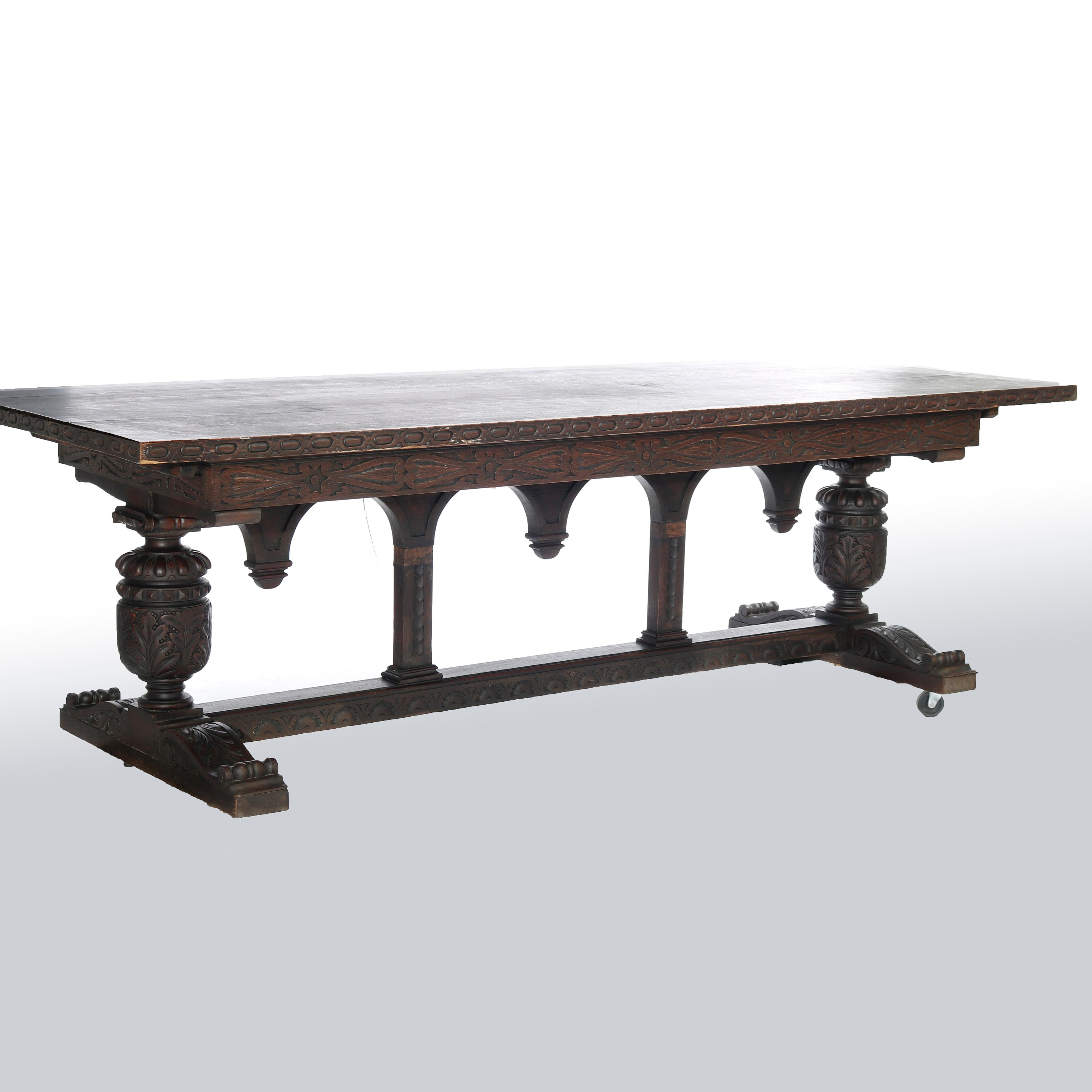 An antique and large English Jacobean dining or conference table offers walnut construction with slab top surmounting trestle base having carved foliate design throughout, drop finials and raised on urn form legs, 19th century


Measures- 30.75''