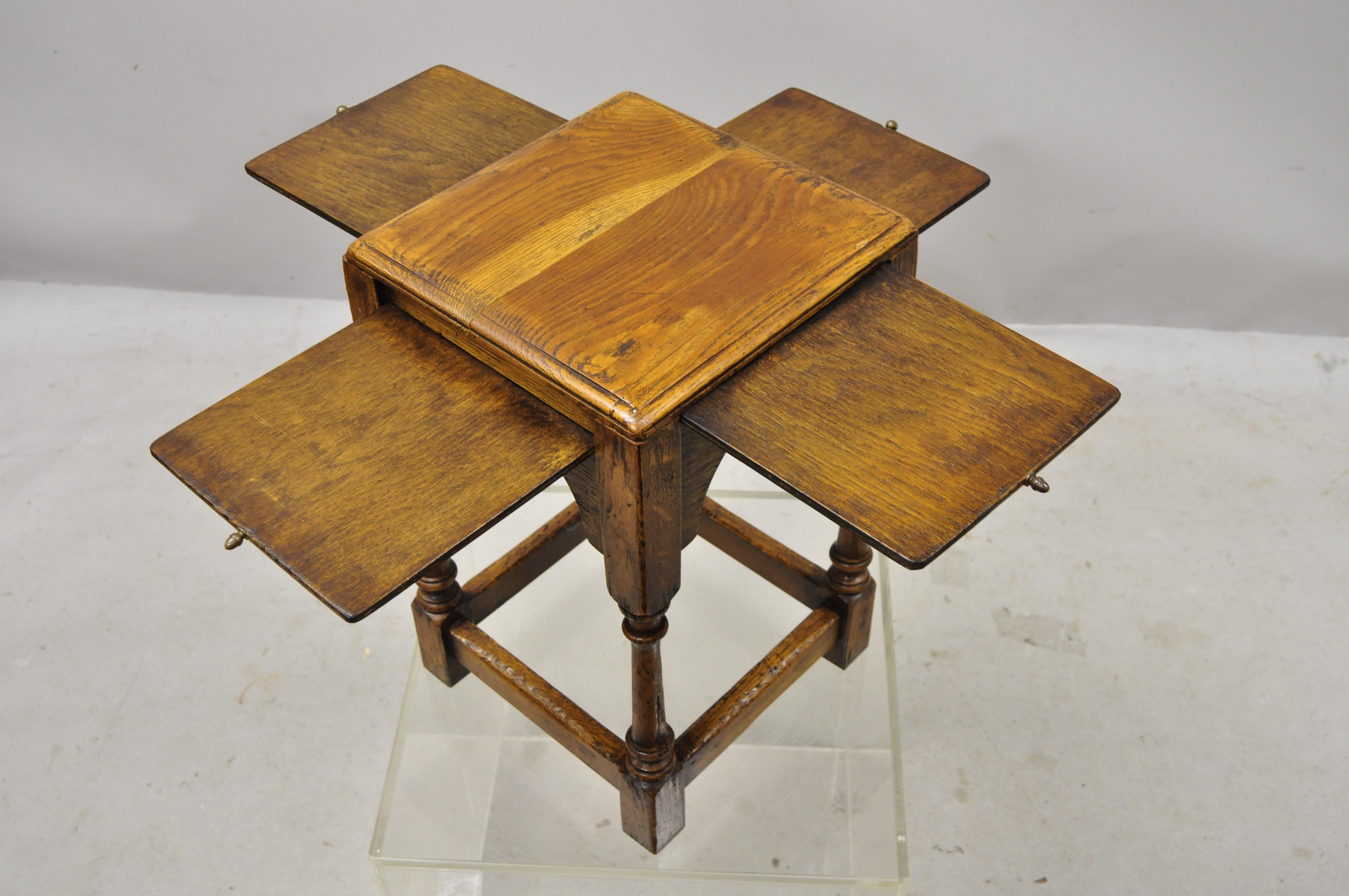Antique English Jacobean oakwood small accent side table with 4 pullout surfaces. Item features (4) Pull out surfaces, turn carved legs, solid wood construction, distressed finish, nicely carved details, solid brass hardware, quality craftsmanship,