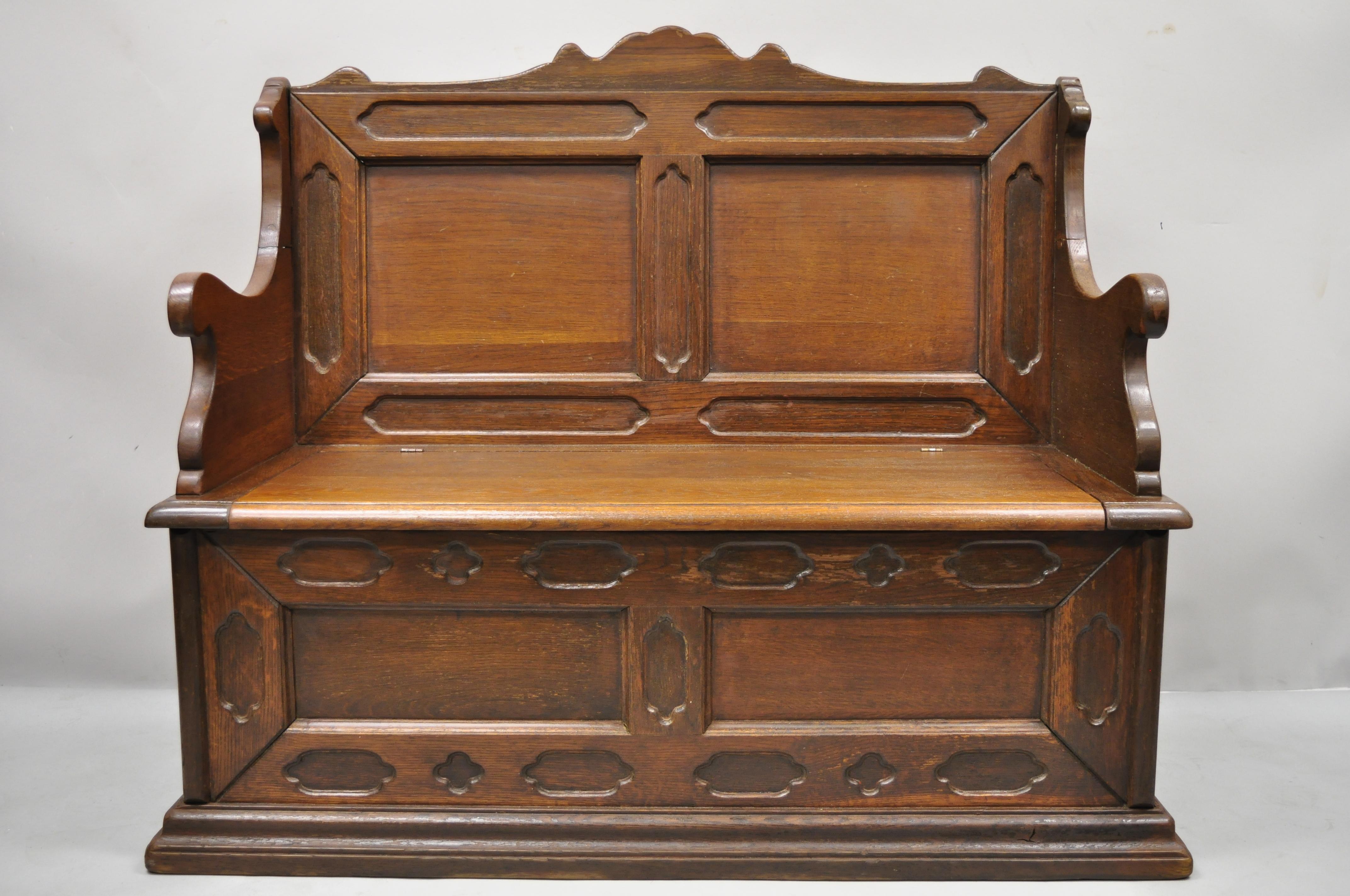 Antique English Jacobean Renaissance Revival oak wood pew bench with storage lid. Item features lift seat with storage, solid wood construction, beautiful wood grain, nicely carved details, very nice antique item, great style and form. Circa Early