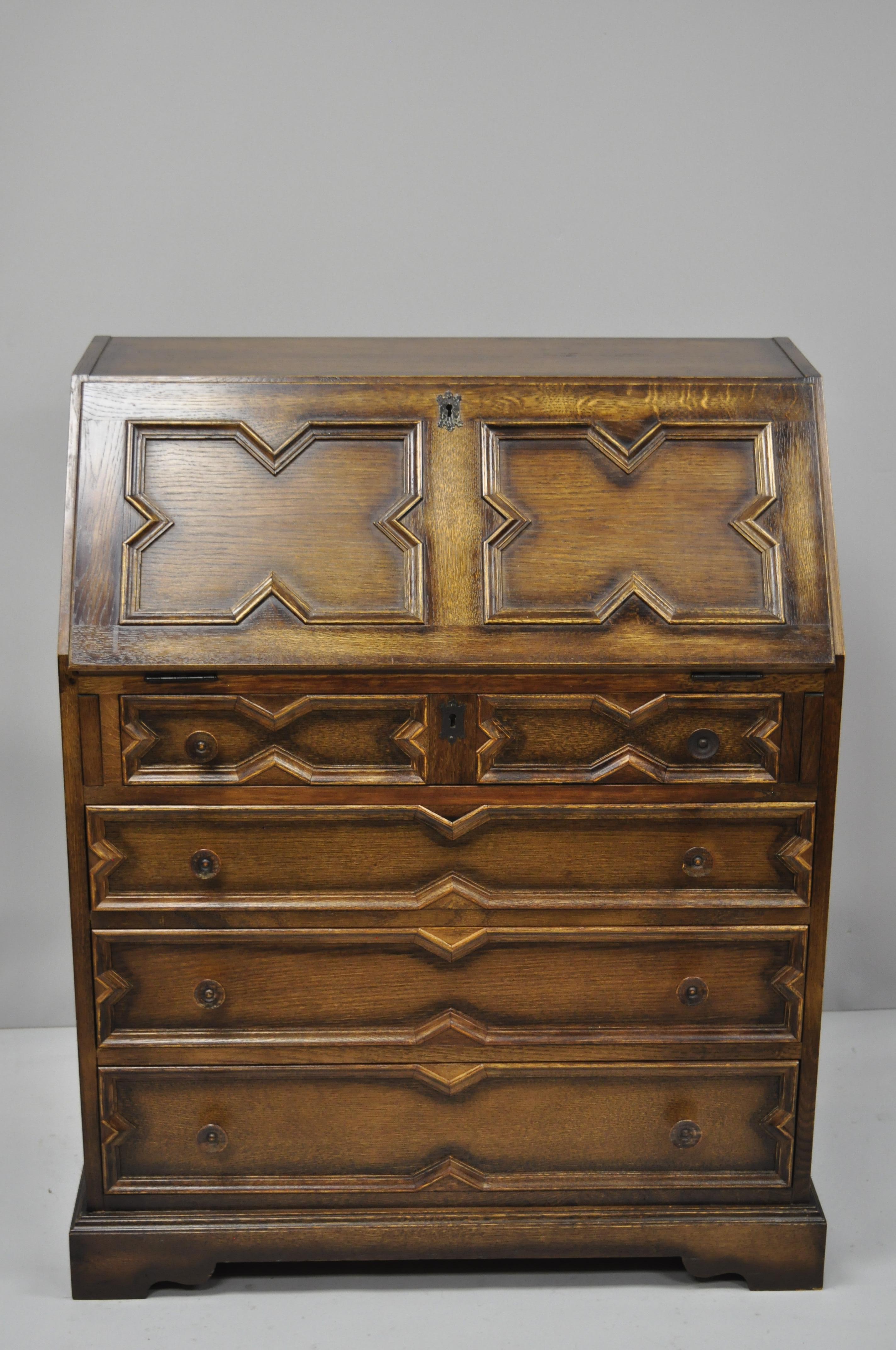 Antique English Jacobean style tiger oak wood drop front Secretary desk. Item features fitted interior, solid wood construction, beautiful wood grain, nicely carved details, 4 drawers, circa early 20th century. Measurements: 39