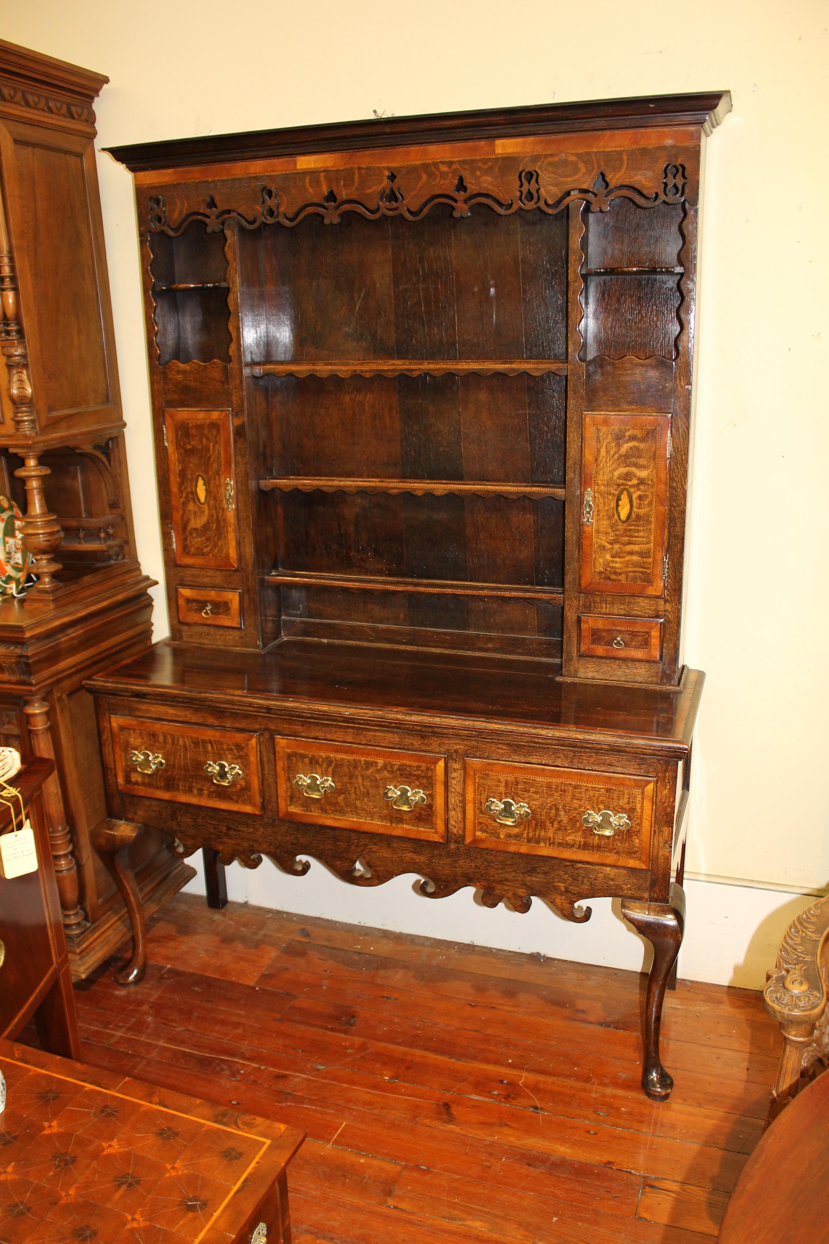 Fabulous quality and superb color antique English Lancashire region inlaid and cross-banded oak welsh dresser and rack with pierced cornice frieze and shaped and carved apron

Standing upon Queen Anne style cabriole legs. Handsome 