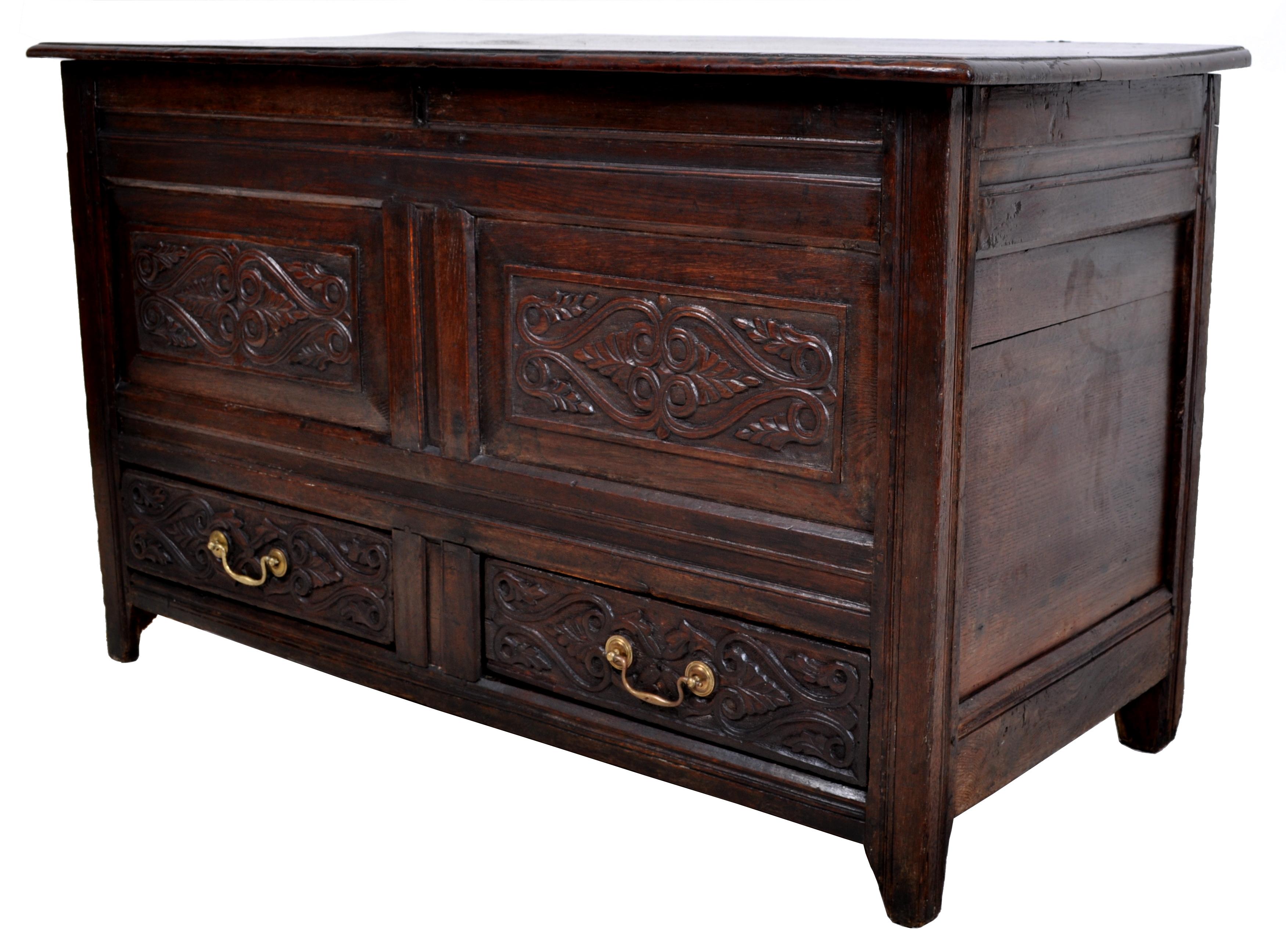 A good antique English late 17th century carved oak mule chest / coffer, circa 1680. The mule chest having a hinged lift-up lid enclosing a storage reservoir and decorated to the front with a pair of carved panels, the base having two drawers with