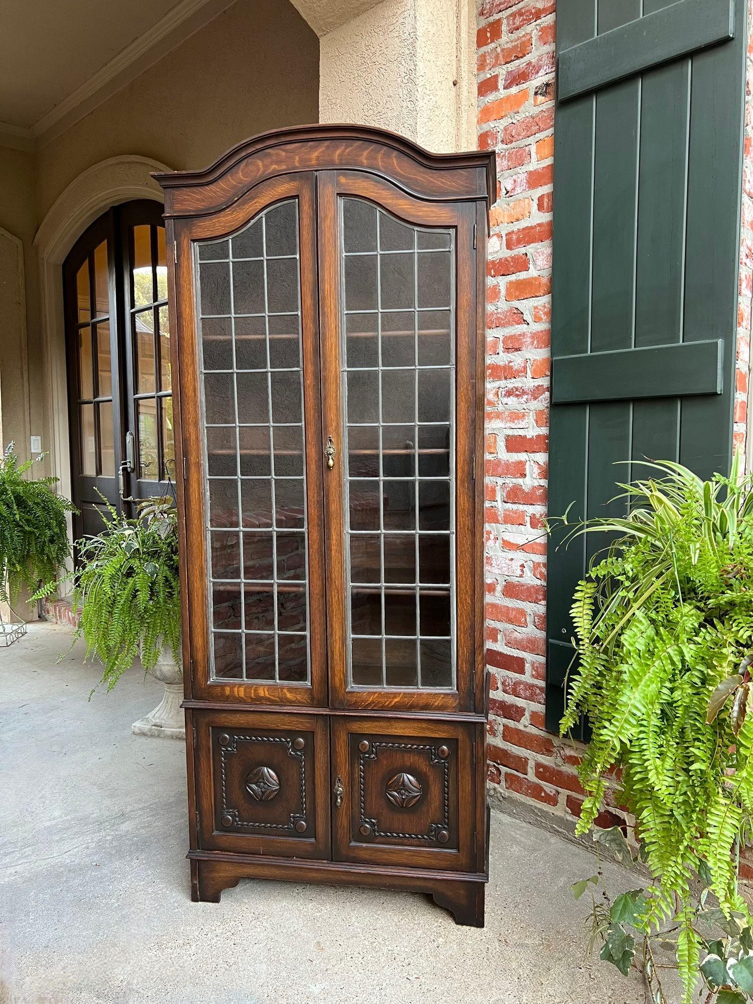 Antique English Leaded Glass Door Bookcase Display Cabinet Oak Jacobean with Dome Top.

Direct from England, a TALL and lovely antique English bookcase!  We love the long leaded glass double doors, with arched shape tops, all original! Above the