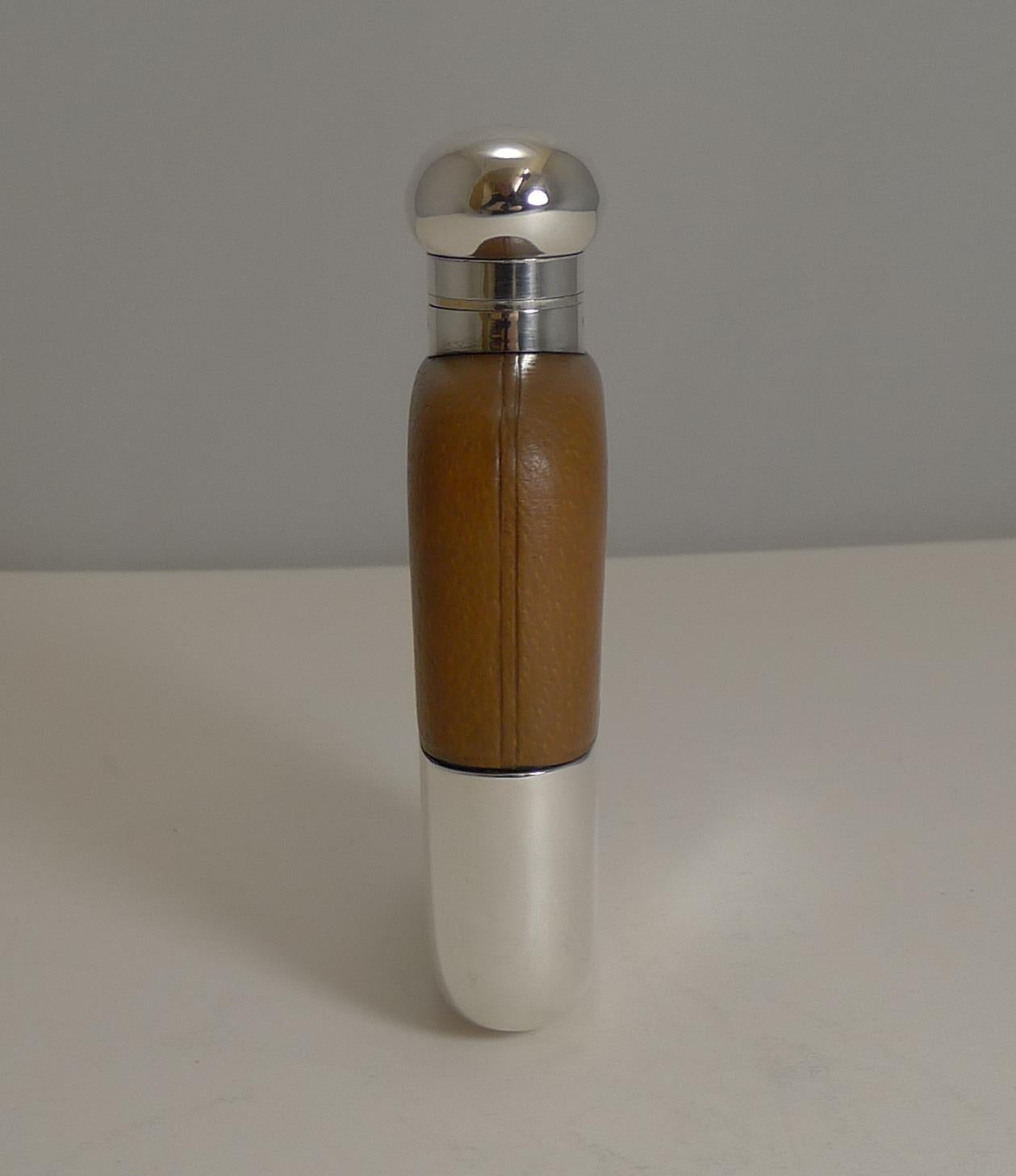 A handsome antique English hip flask which looks like it has hardly ever been used since made in around 1910 / 1920. The top of the flask is clad in a cognac coloured leather.

The glass flask has silver plated fittings and is made by the