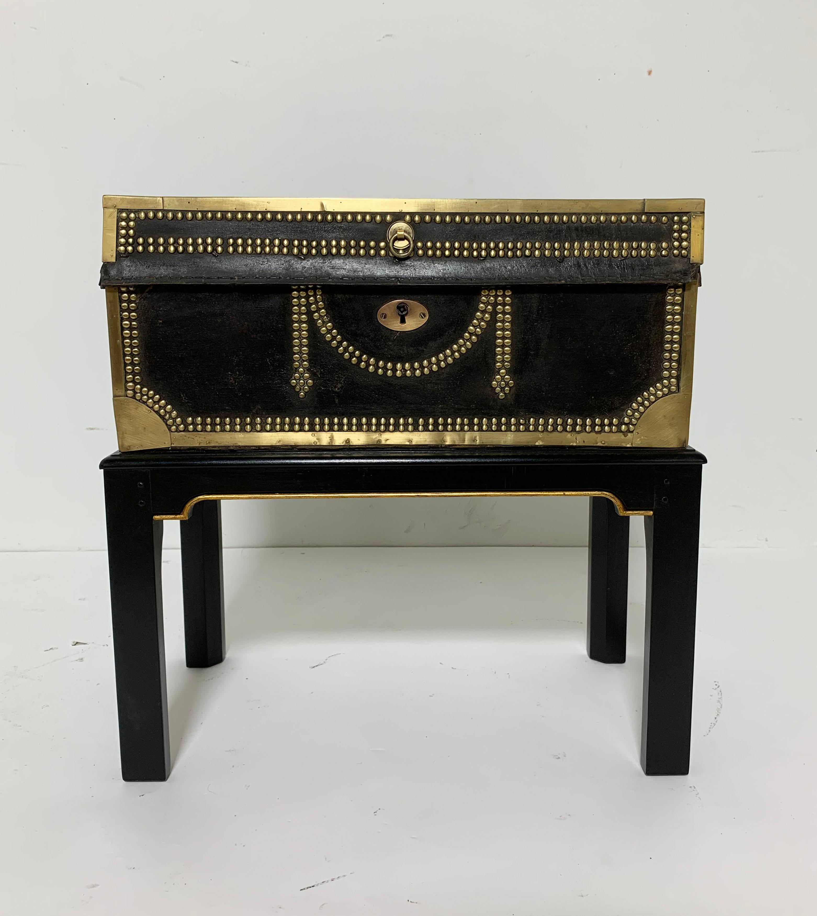 English brass studded leather and camphorwood military chest, circa 1820s. Fitted on (and removable from) a vintage lacquered wood stand.