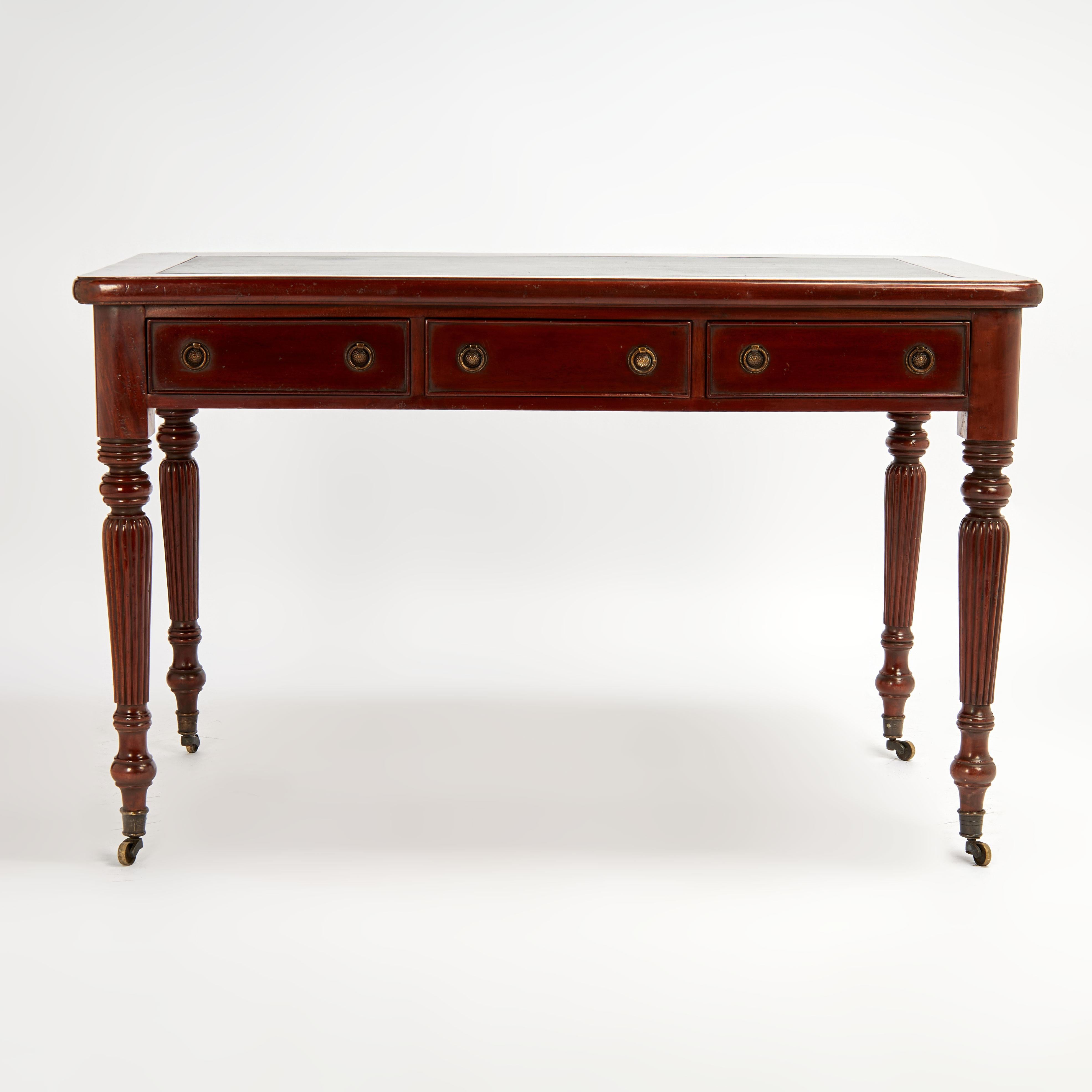 Magnifique bureau anglais du 19e siècle avec un plateau en cuir sur une caisse avec trois tiroirs à l'avant, des ferrures en laiton et des faux tiroirs sur les côtés et à l'arrière, le tout reposant sur des pieds tournés et cannelés avec des