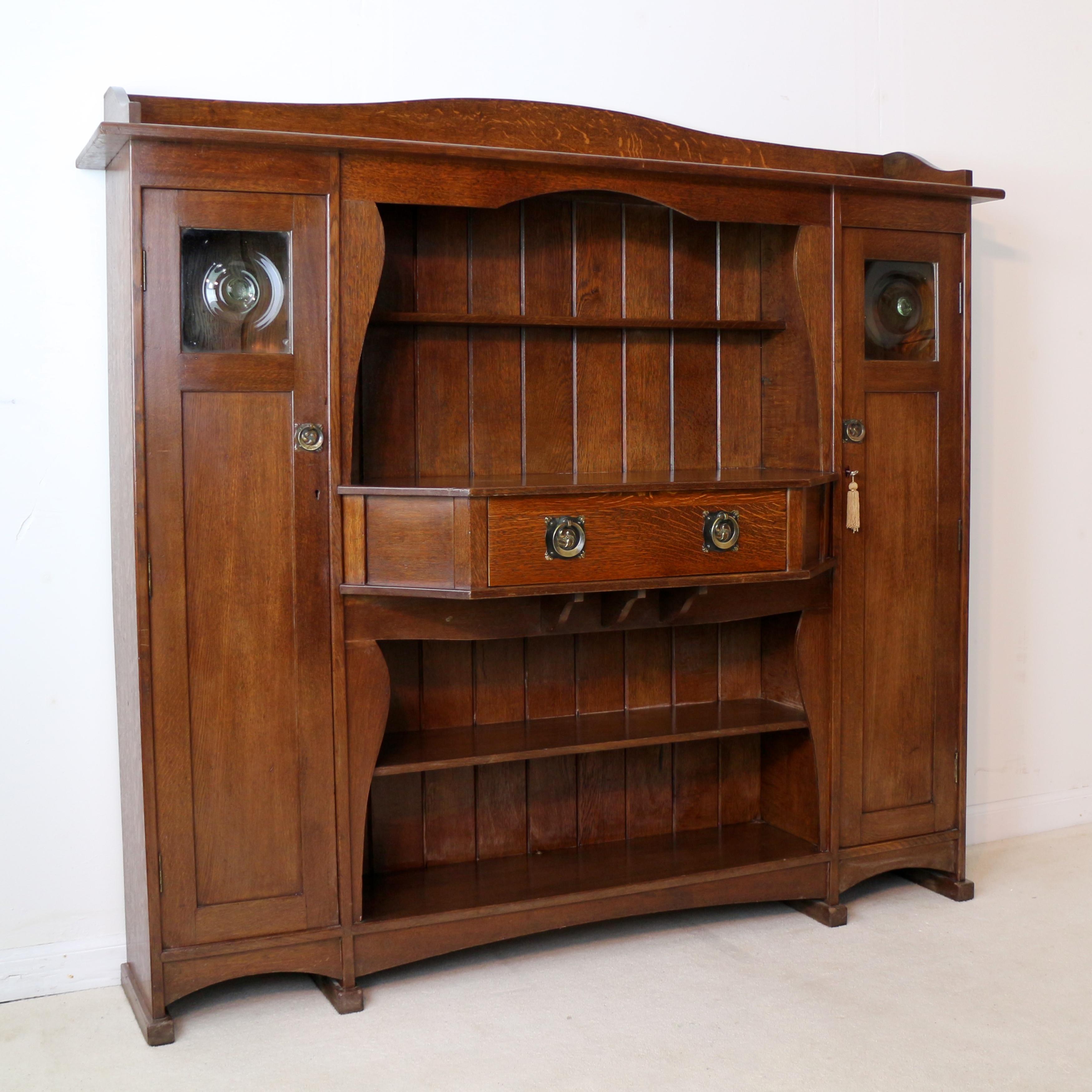 A handsome Arts & Crafts oak ‘Hathaway’ design sideboard or dresser by Liberty & Co of London. This sought after dresser was designed by the celebrated Leonard Wyburd for Liberty's circa 1900. Featuring a raised and shaped gallery back above an