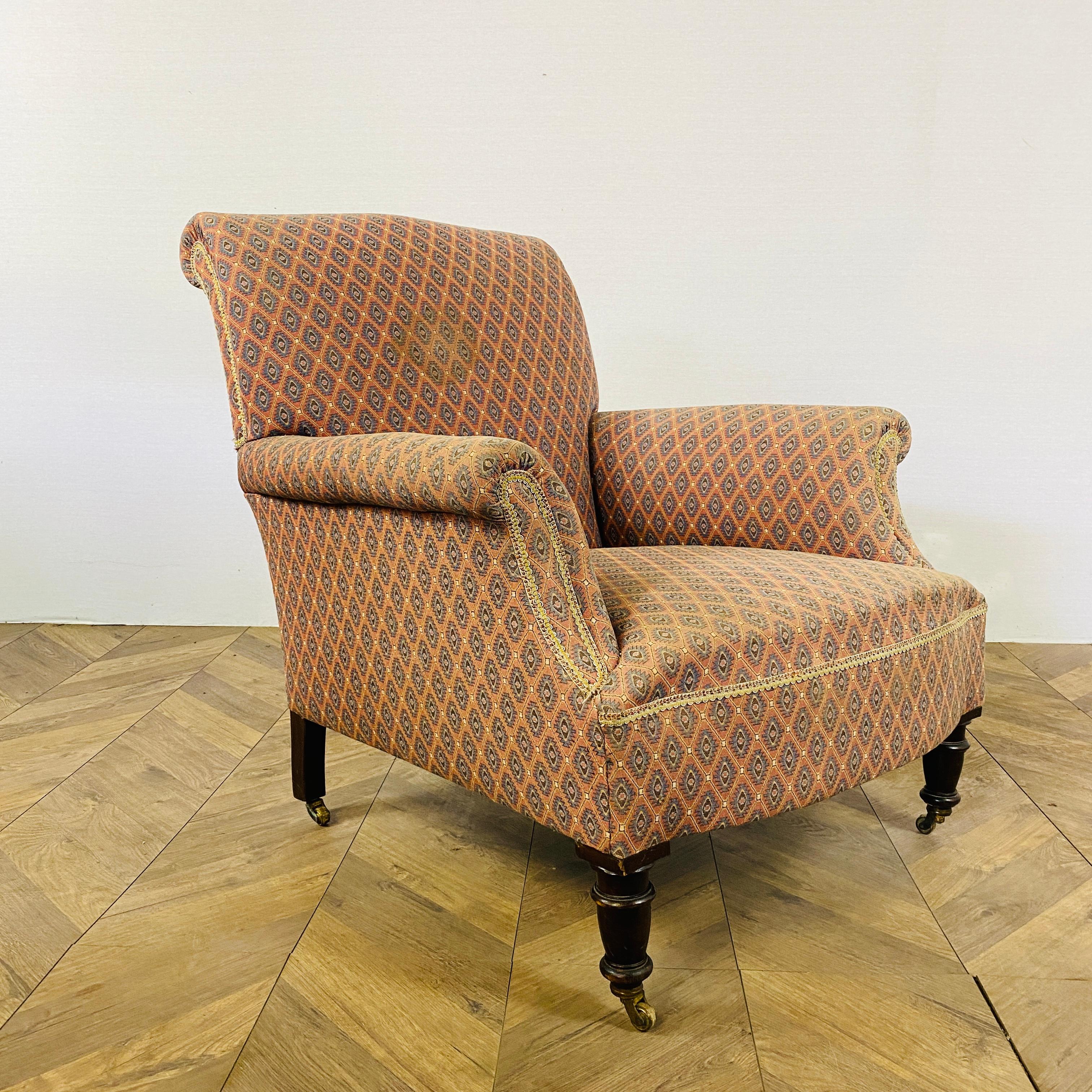 A Well Proportioned, Victorian Library Armchair, in the manner of Howard & Sons or Jas Shoolbred. Circa 1890s.

The armchair features a lovely a rolled top, turned front legs and set on original brass casters.

The fabric is in fair condition