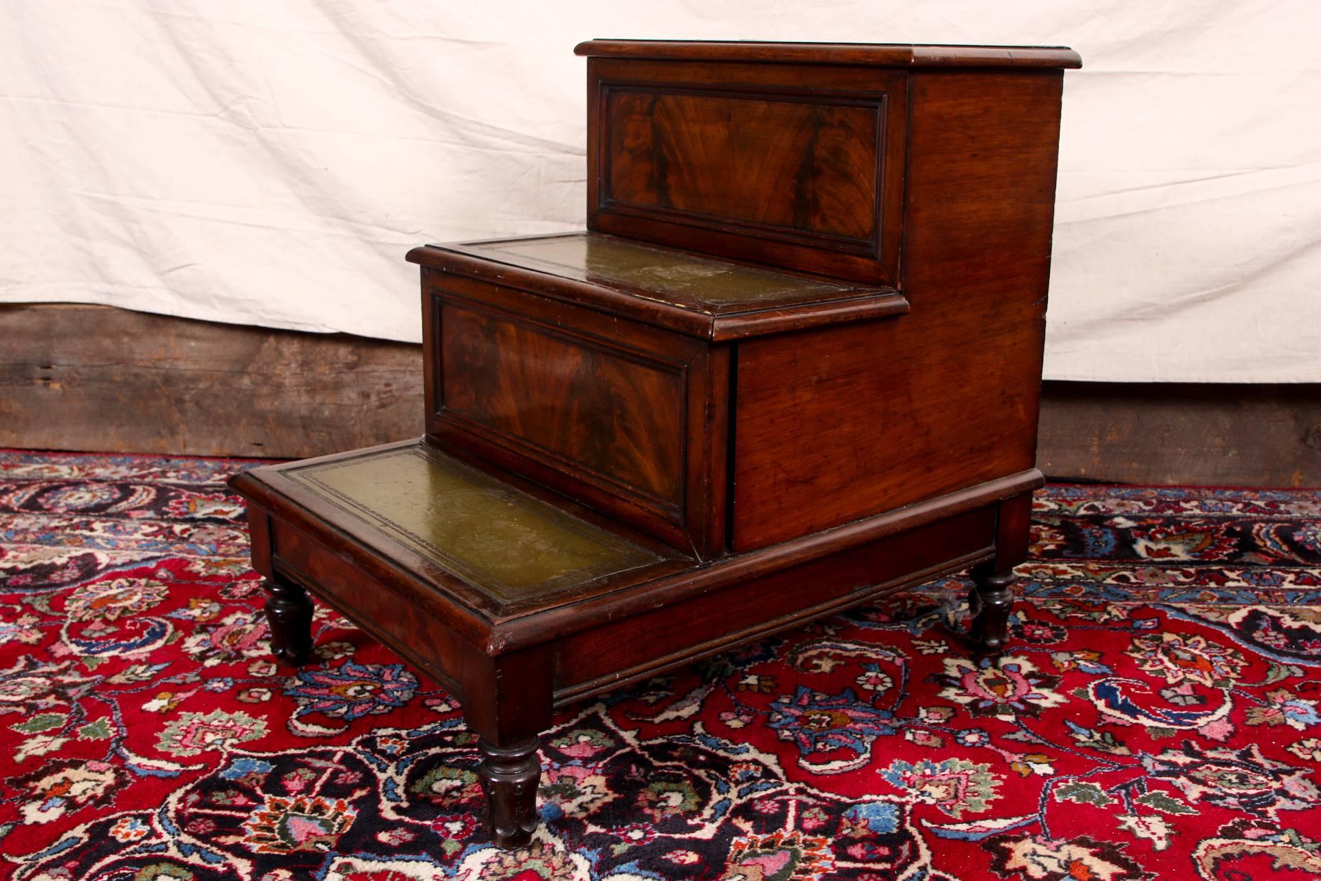 Antique English library stairs or bedside tables, circa 1840, walnut with three step tiers with burled carved recessed panels on front, green tooled leather tops and raised on finely carved leafy feet. The top lifts up. 

Condition: Expected wear