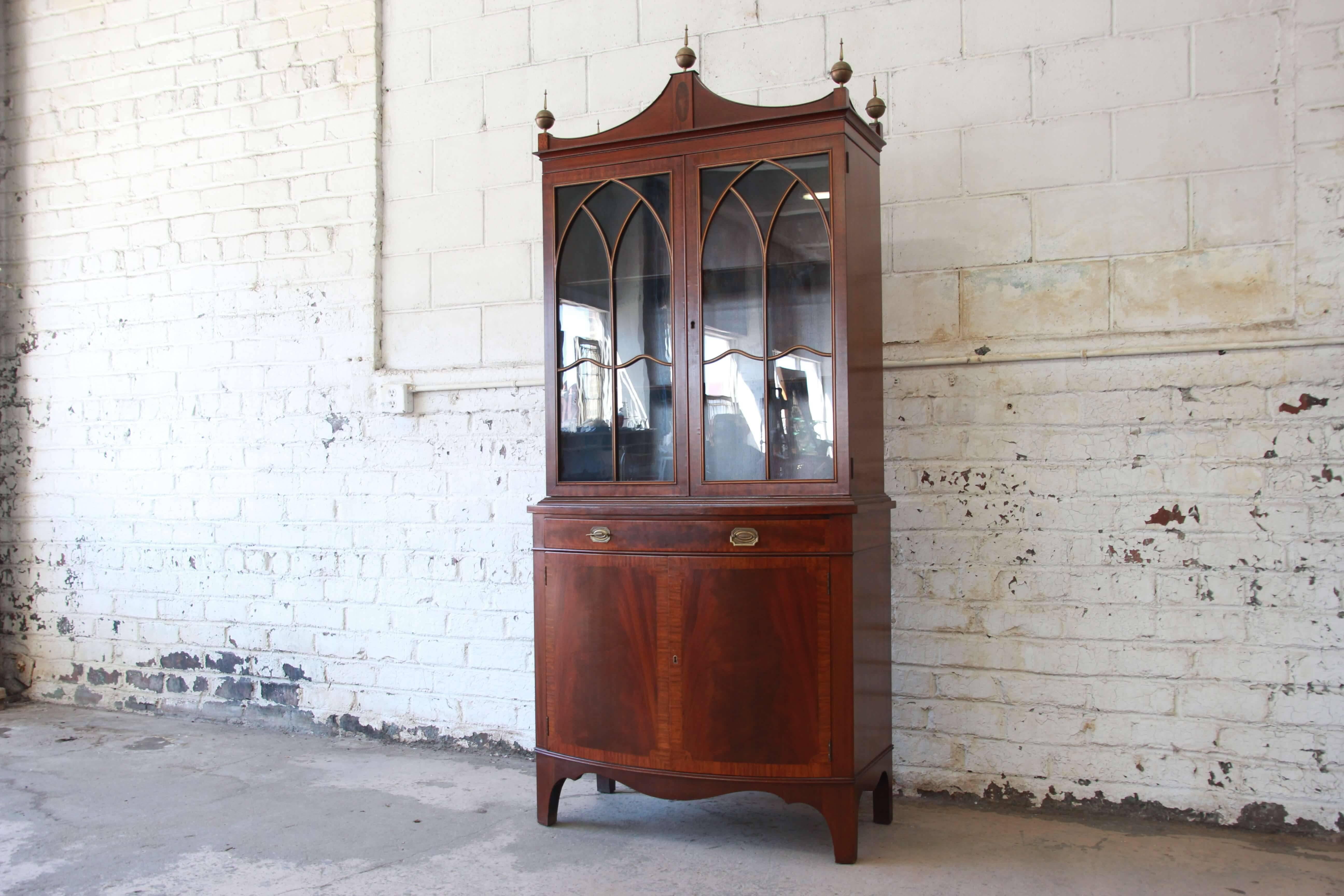 Offering a very nice banded edge English mahogany cabinet. The cabinet has beautiful mahogany graining with banded edge doors and drawers. Two glass doors have nice detailed cathedral design and open up to two adjustable wooden shelved great for