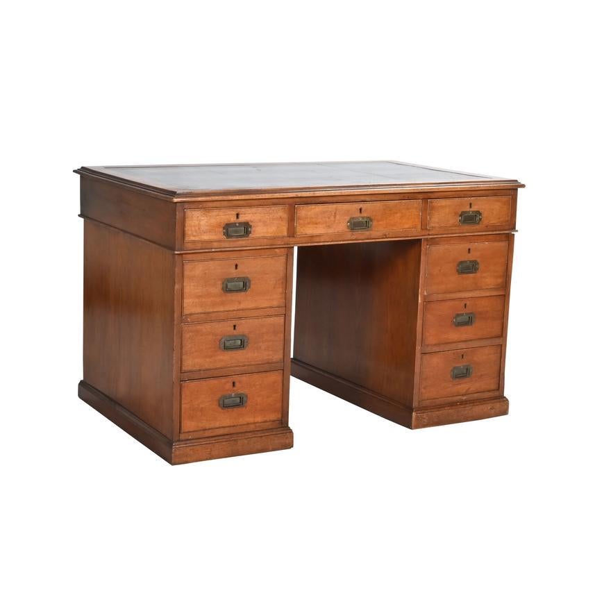 Circa 1860 English Mahogany Campaign Desk with inset brass pulls and inset tooled gilt black leather top constructed in three sections -  the top section with three drawers; each of the double pedestal base sections with three drawers.