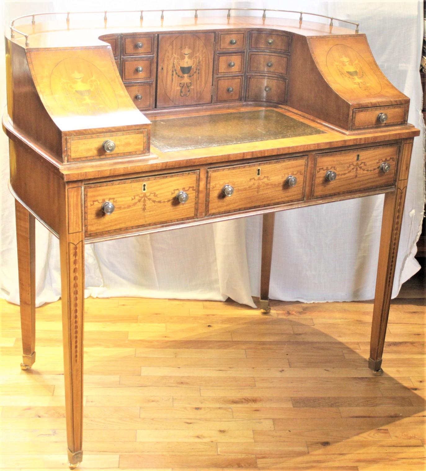 This Carlton House desk or writing table is unsigned, but presumed to have been made in England in approximately 1920 in a Georgian style. The desk is done in a veneer with nicely executed classical urn and blue bell marquetry panels on either side