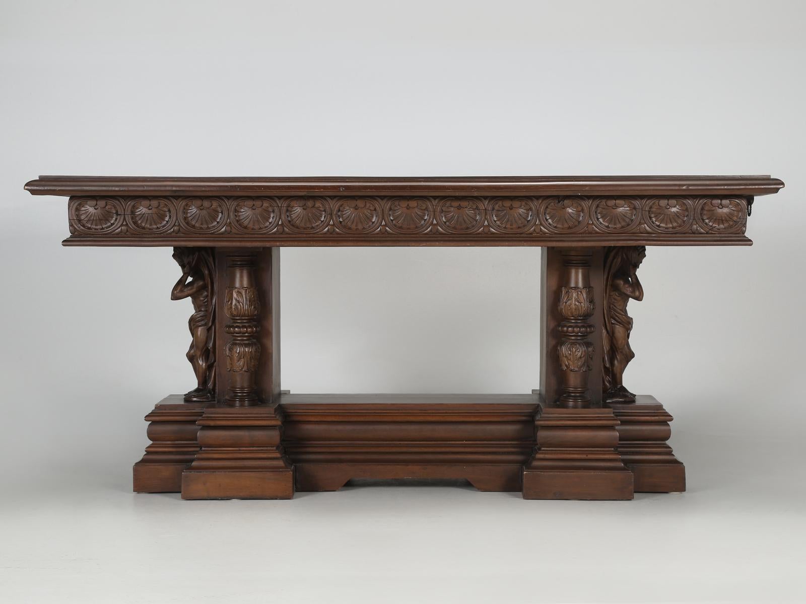 Antique English carved mahogany library table, or since it has built in steel-lopers that pull-out from each end, one could use this antique English library table as a dining room table or very large desk. The surface of the mahogany does have many