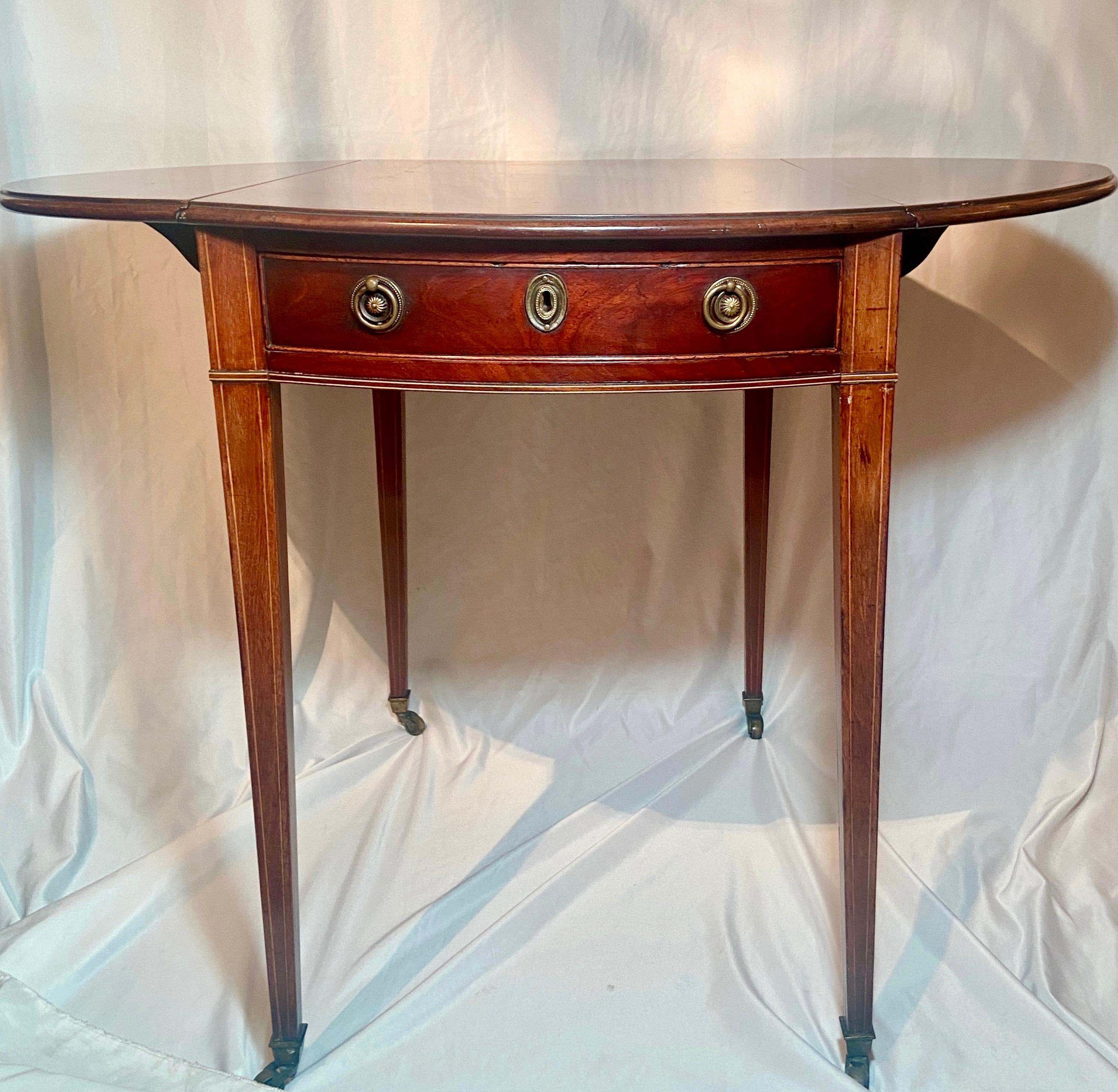 Antique English Mahogany George III Pembroke (Drop Leaf) table, Circa 1810-1820.
Measures: Height: 28 inches
Diameter (open): 37.5 inches 
Depth (closed): 30.75 inches.