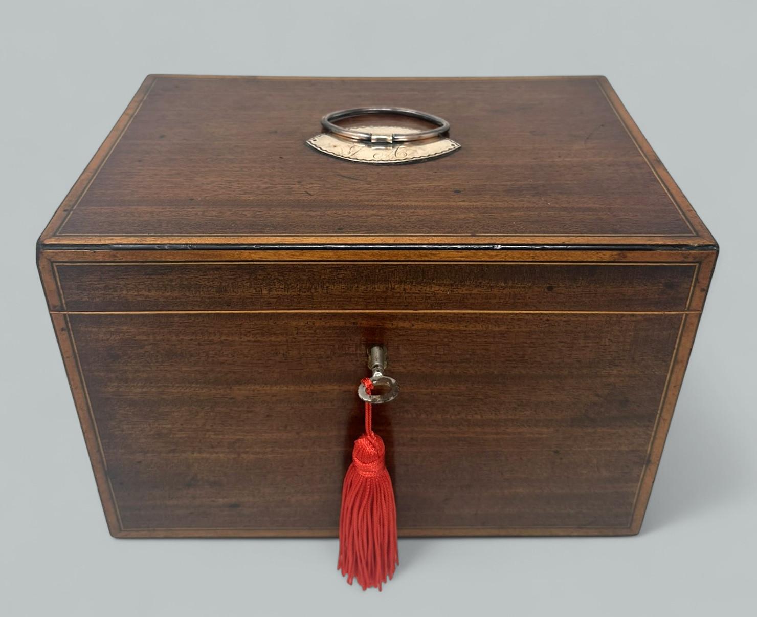 Espléndido ejemplo de caddie de té de doble sección interior de caoba bien labrada de la época georgiana inglesa, de contorno rectangular plano, proporciones generosas y calidad sobresaliente, todas las zonas están ribeteadas con incrustaciones de