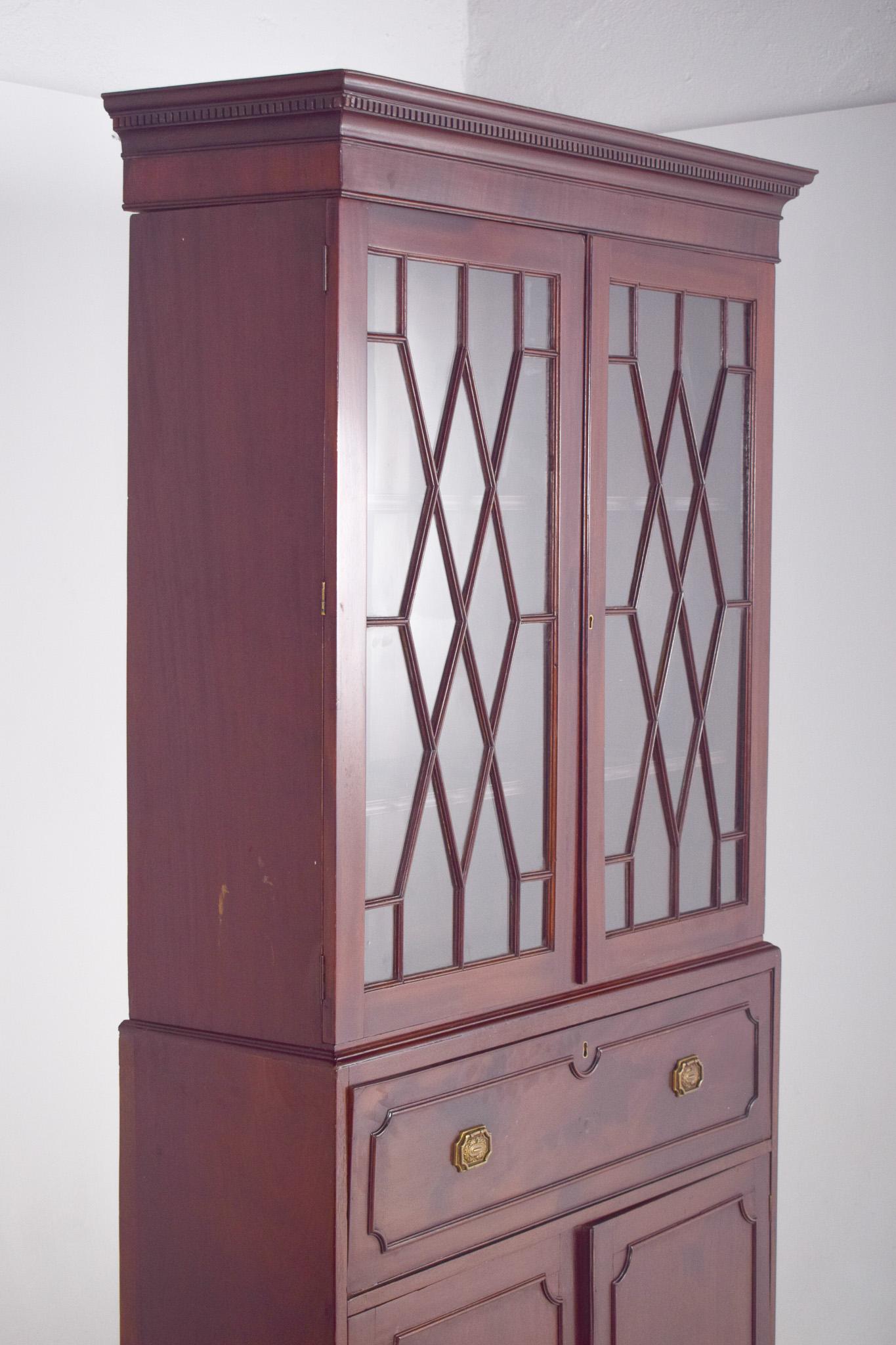 L'immagine mostra un mobile da segreteria a due pezzi in mogano di Giorgio III, un ottimo esempio di artigianato del XVIII secolo. Il mobile è costruito in ricco mogano, un legno scelto per la sua bellezza e durata, che ha sviluppato una patina