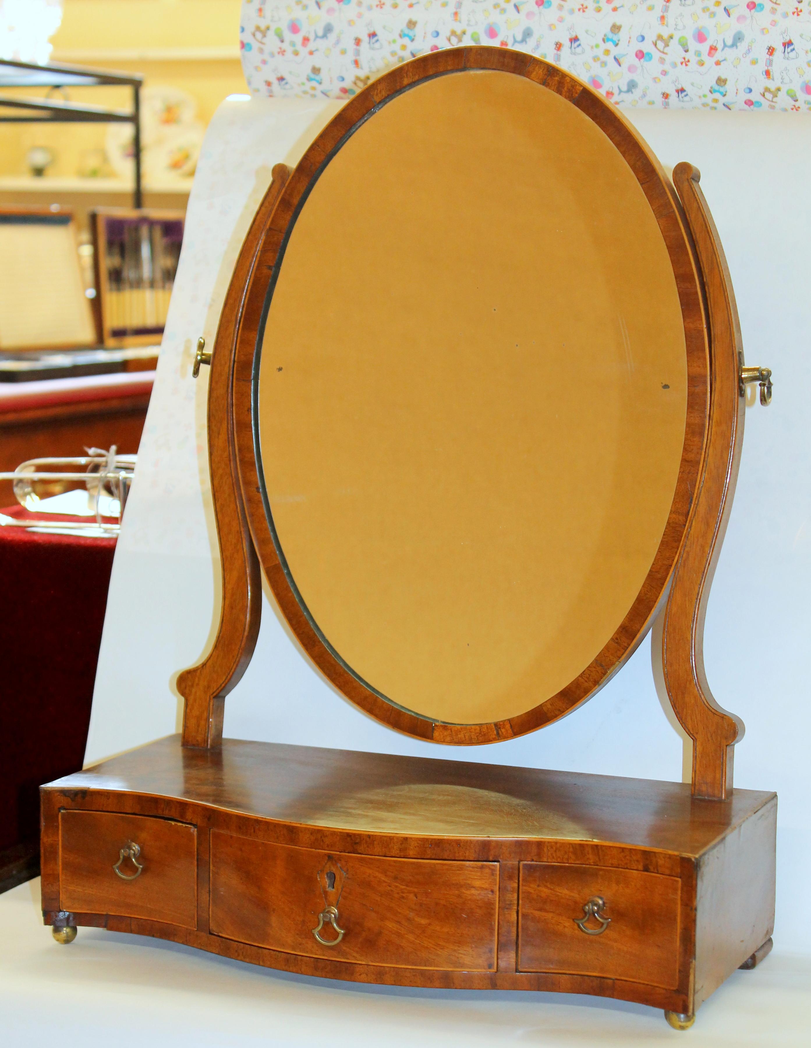 Very fine antique English Geo. III Mahogany shaving mirror with superb, rare serpentine shape, original oval mahogany frame adjustable mirror and original hardware. Please note the handsome highly figured 