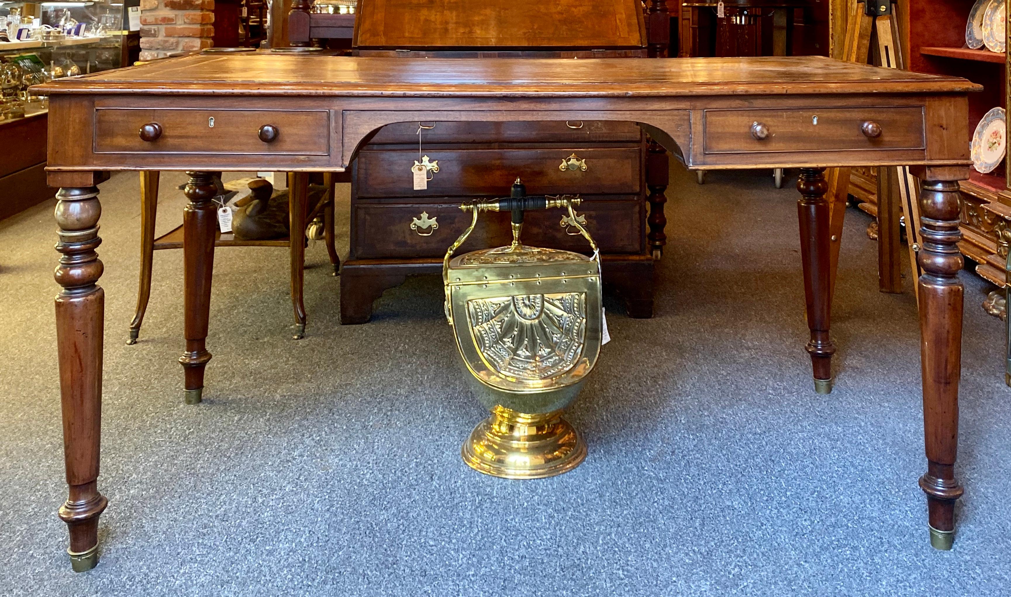 Antique English mahogany table desk circa 1890 with working drawers on one side and false drawers on opposite side and a desktop featuring beautiful leather inlay.