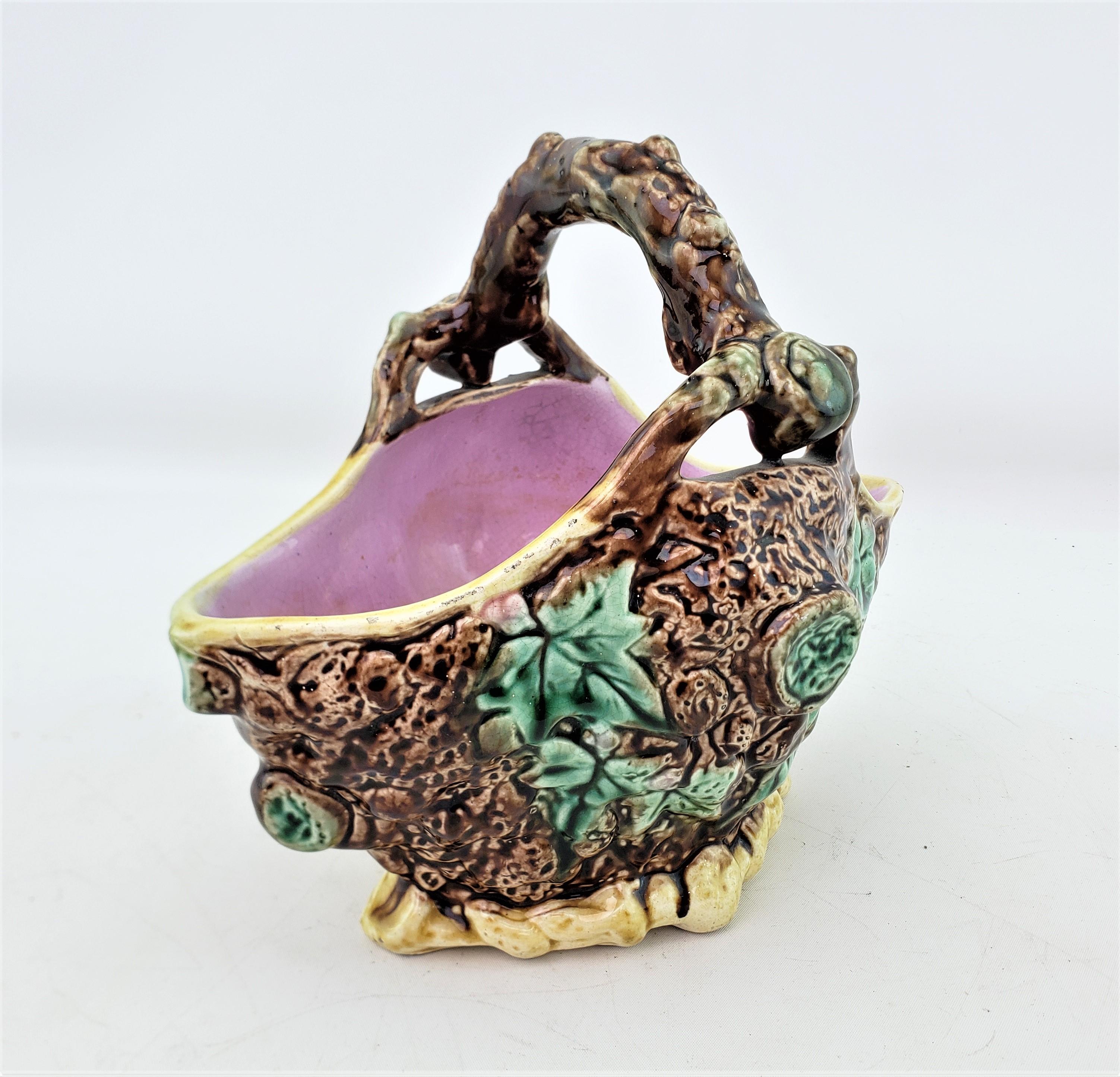 This antique planter is unsigned, but presumed to have originated from England and date to approximately 1890 and done in the period Late Victorian style. The planter is composed of Majolica and done in a figural basket shape with and brown ground