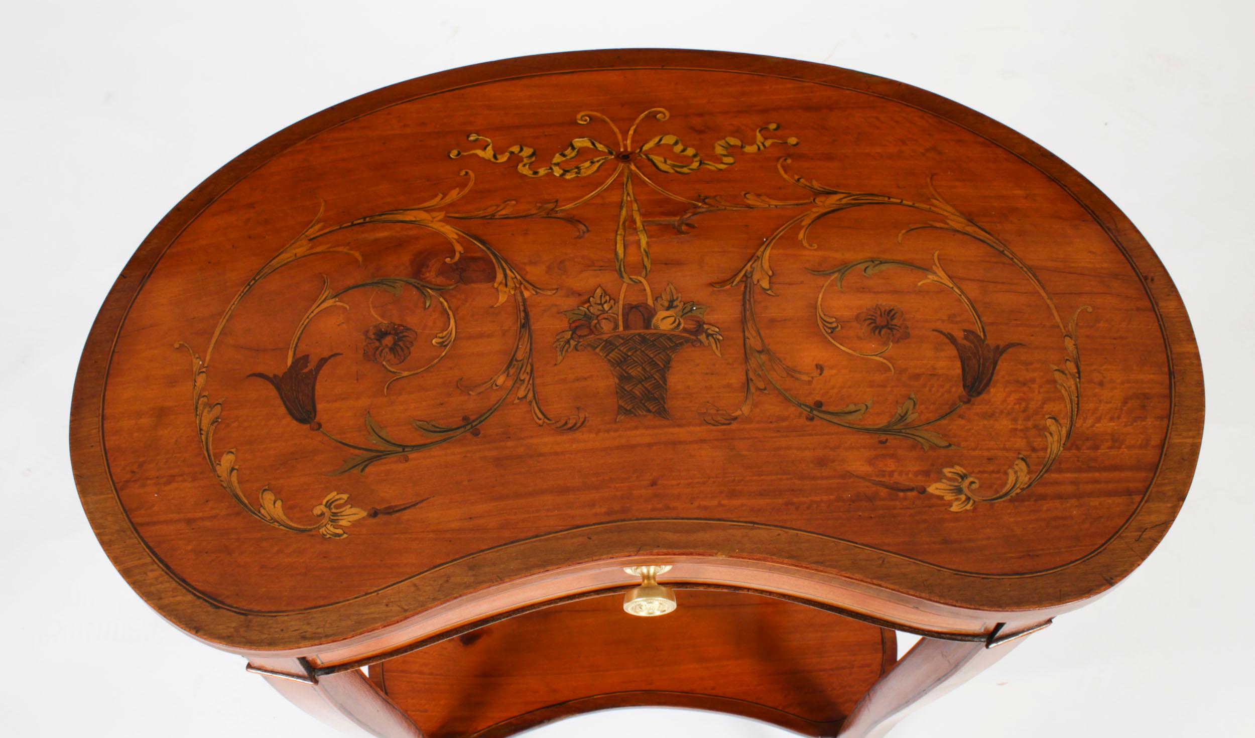 This is a beautiful antique English satinwood kidney shaped satinwood  marquetry inlaid occasional tables, Circa 1880 in date.

The table has a crossbanded top beautifully inlaid with ribbon tied flowers, the frieze with a useful drawer.

It is