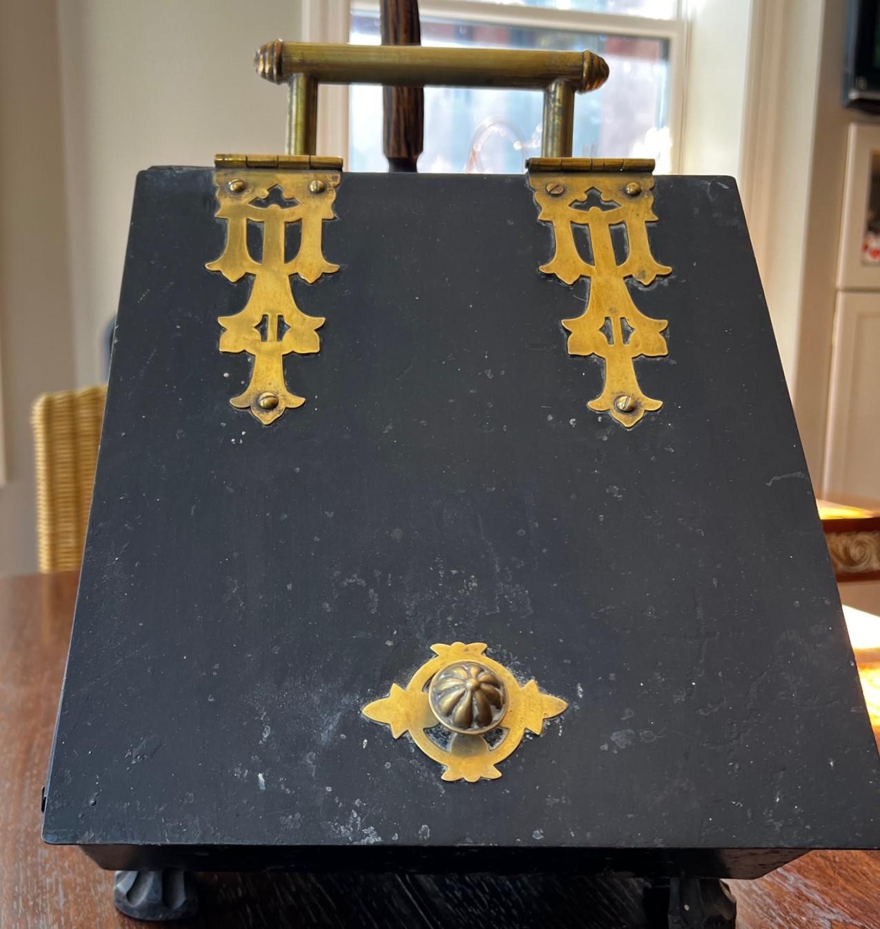 Antique Georgian English footed fireplace coal scuttle with shovel. The carrying handle at the pediment, the knob on the slant door and two elegant door hinges are all in polished brass. The lid opens to reveal a storage compartment for coal, The