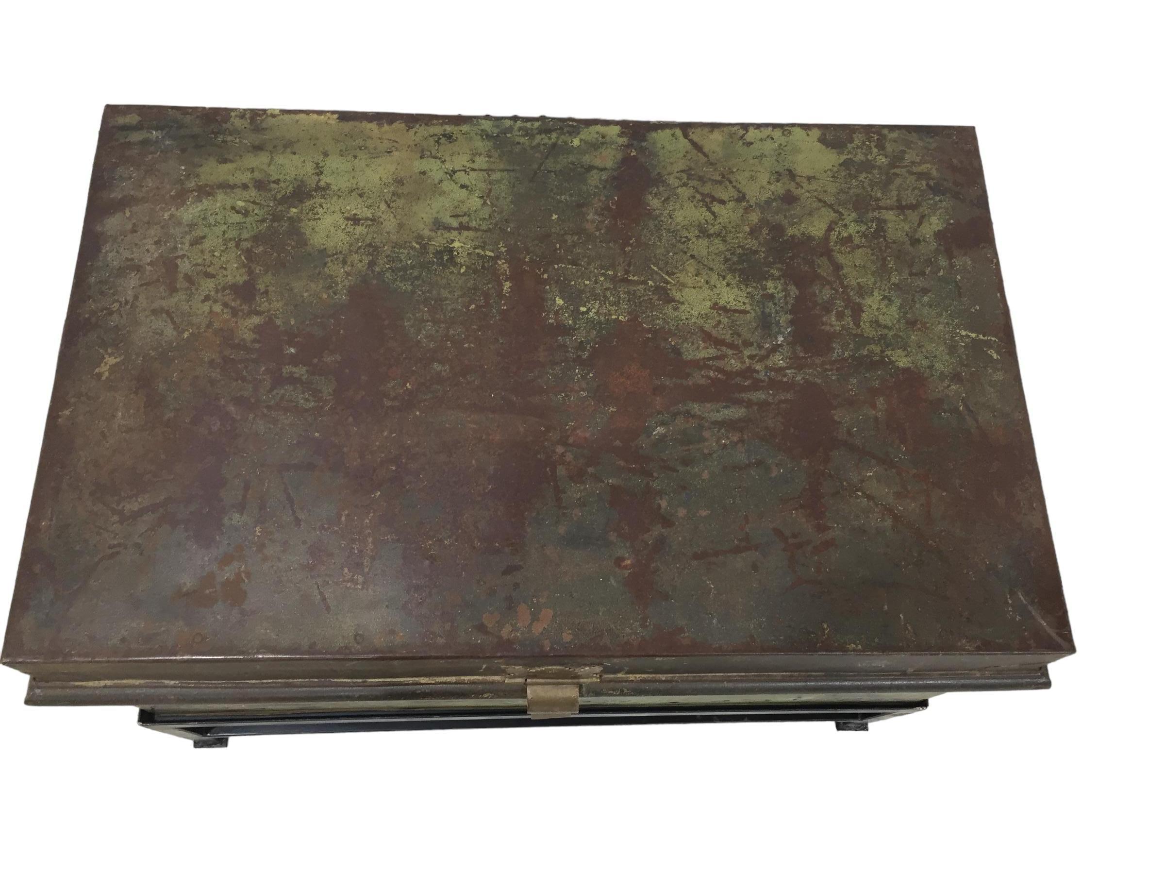 Antique English military metal trunk with brass latch on custom iron base. Trunk shows evidence of daily, loss of paint, adds to the overall authenticity of the trunk.
