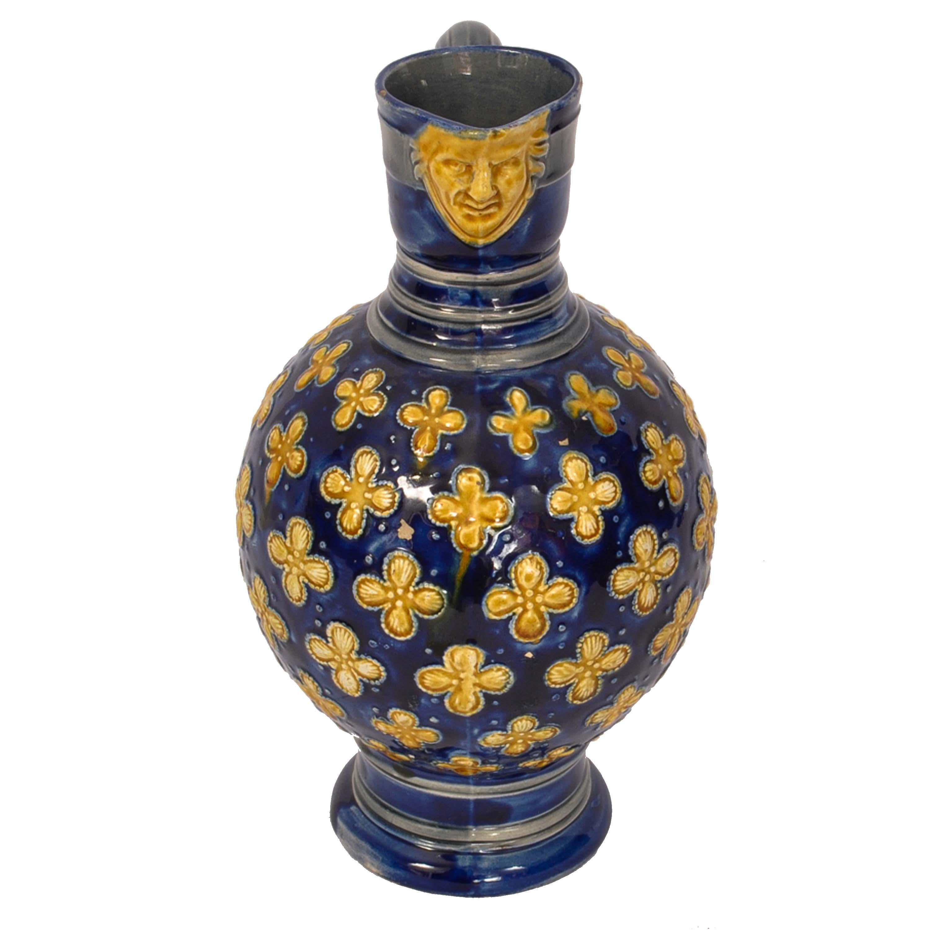 Antique English Minton majolica jug/pitcher, circa 1870.
A very handsome majolica jug, with a cobalt blue background, the spout of the jug is decorated with a yellow glazed mask of a gentleman. The neck having ring turning below a scrolled handle,