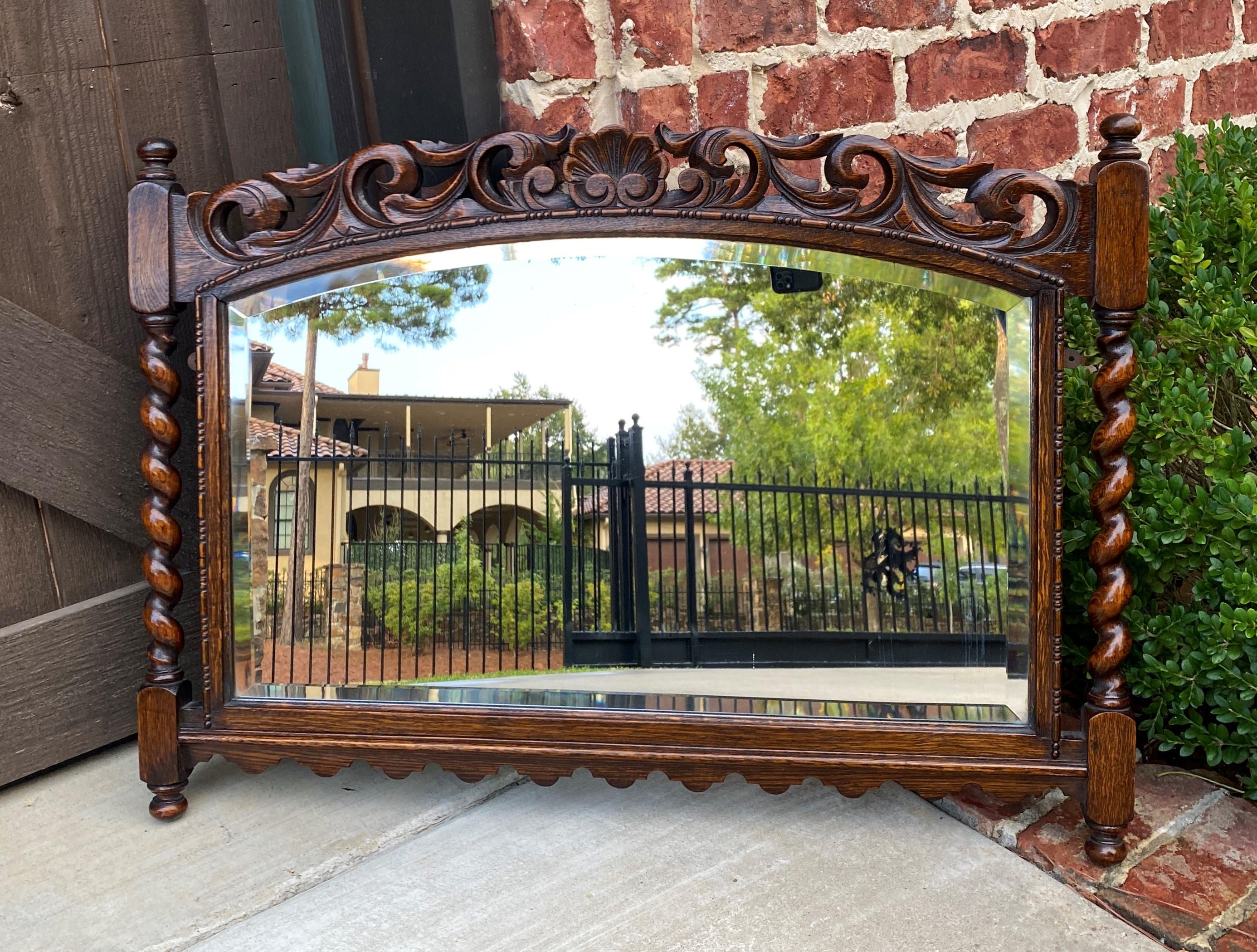 Beautiful antique English oak Jacobean style framed beveled wall mirror with carved crown and barley twist posts~~c. 1930s
 
Popular Jacobean style English framed oak beveled mirror with carved shell crown, barley twist posts and finials, 