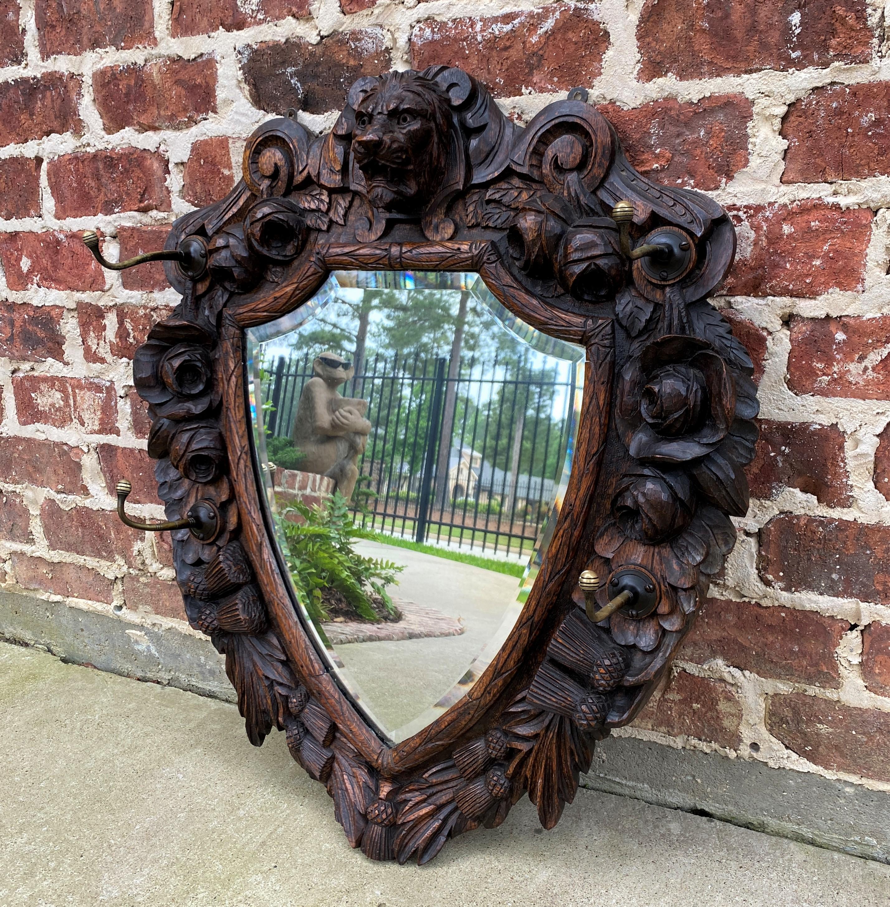BEAUTIFUL & UNIQUE Antique English Oak Renaissance Revival Shield Shaped Framed Wall Mirror with Lions Mask and Hooks~~c. 1900
 
Popular Renaissance Revival English framed oak mirror with carved lions mask, roses and tassels~~unique shield shape