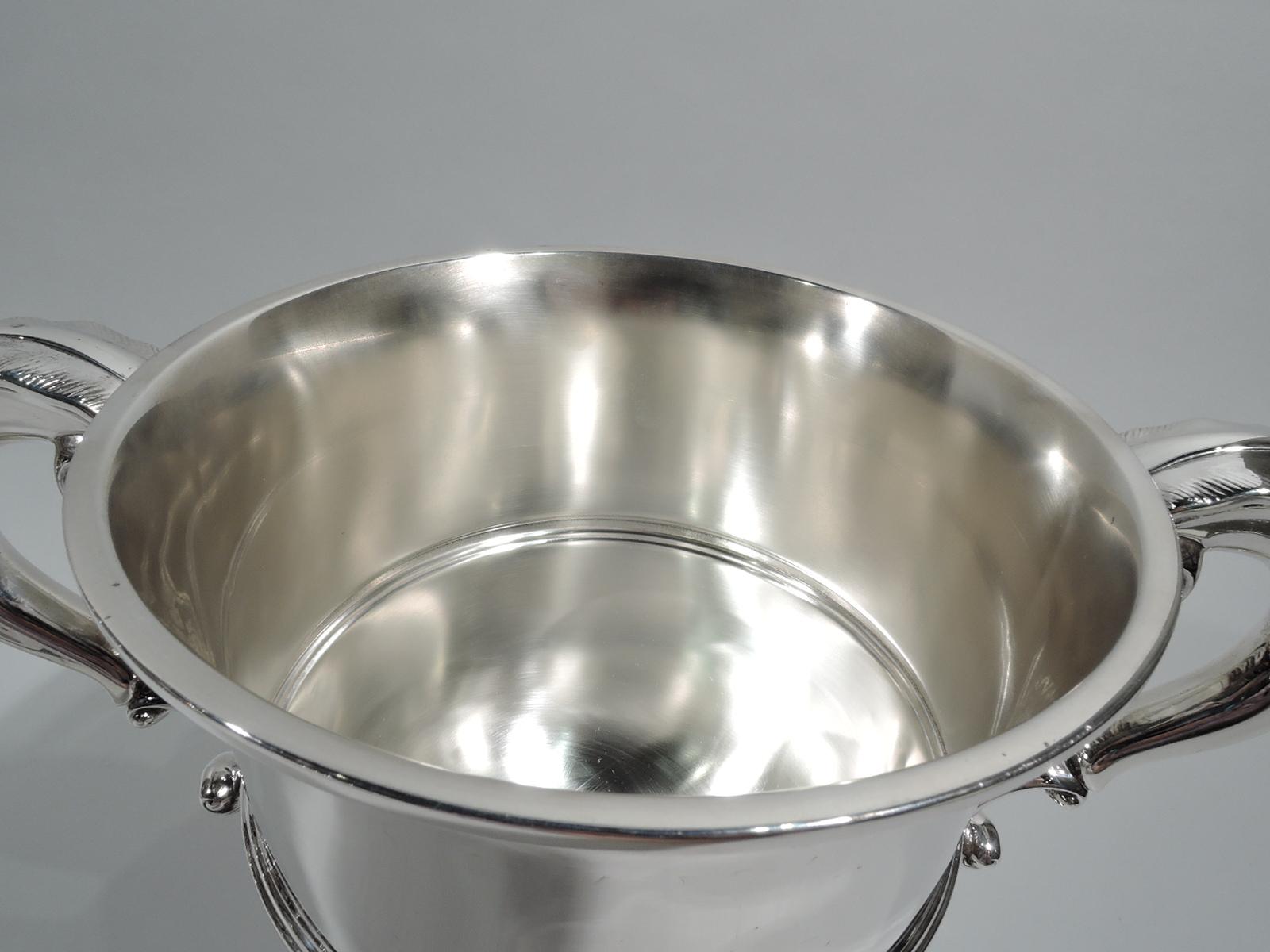 George V sterling silver trophy cup. Made by Adie Bros in Birmingham in 1925. Girdled urn with leaf-capped s-scroll side handles and domed foot. Timeless Classical form with plenty of room for engraving. Fully marked. Weight: 23.5 troy ounces.