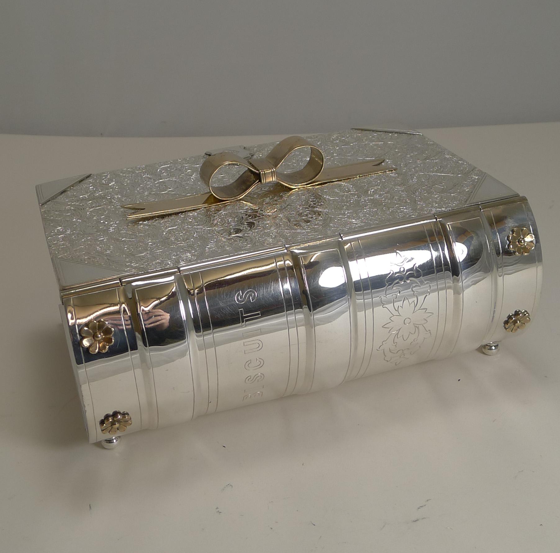 A rare biscuit box made in silver plate in the form of a book standing on four original little feet.

The 