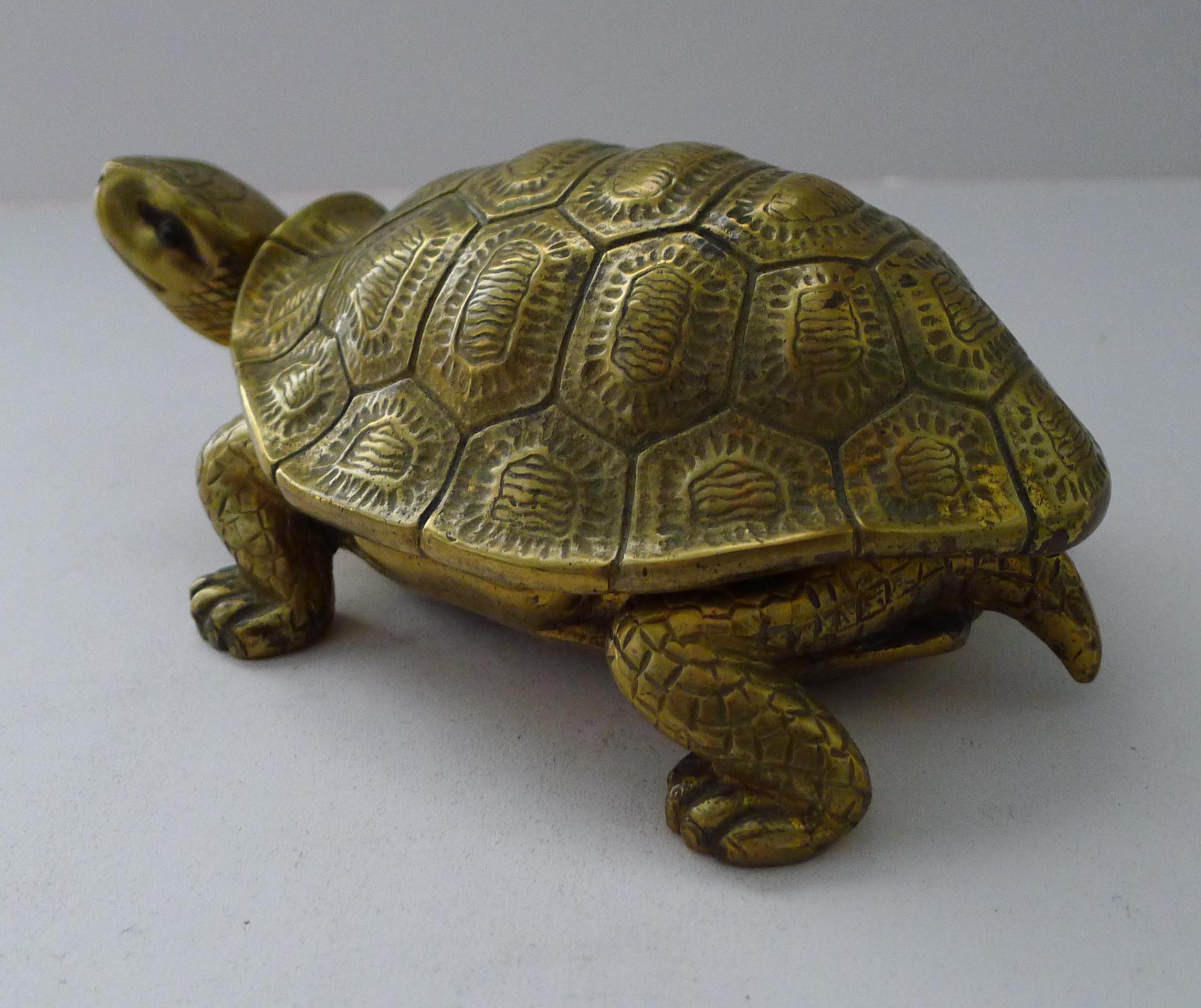 A handsome antique English inkwell cast in solid English brass in the form of a Tortoise retaining his original glass eyes.

The lid lifts to reveal a glass ink chamber, removable for cleaning.

Dating to the late Victorian era or early Edwardian