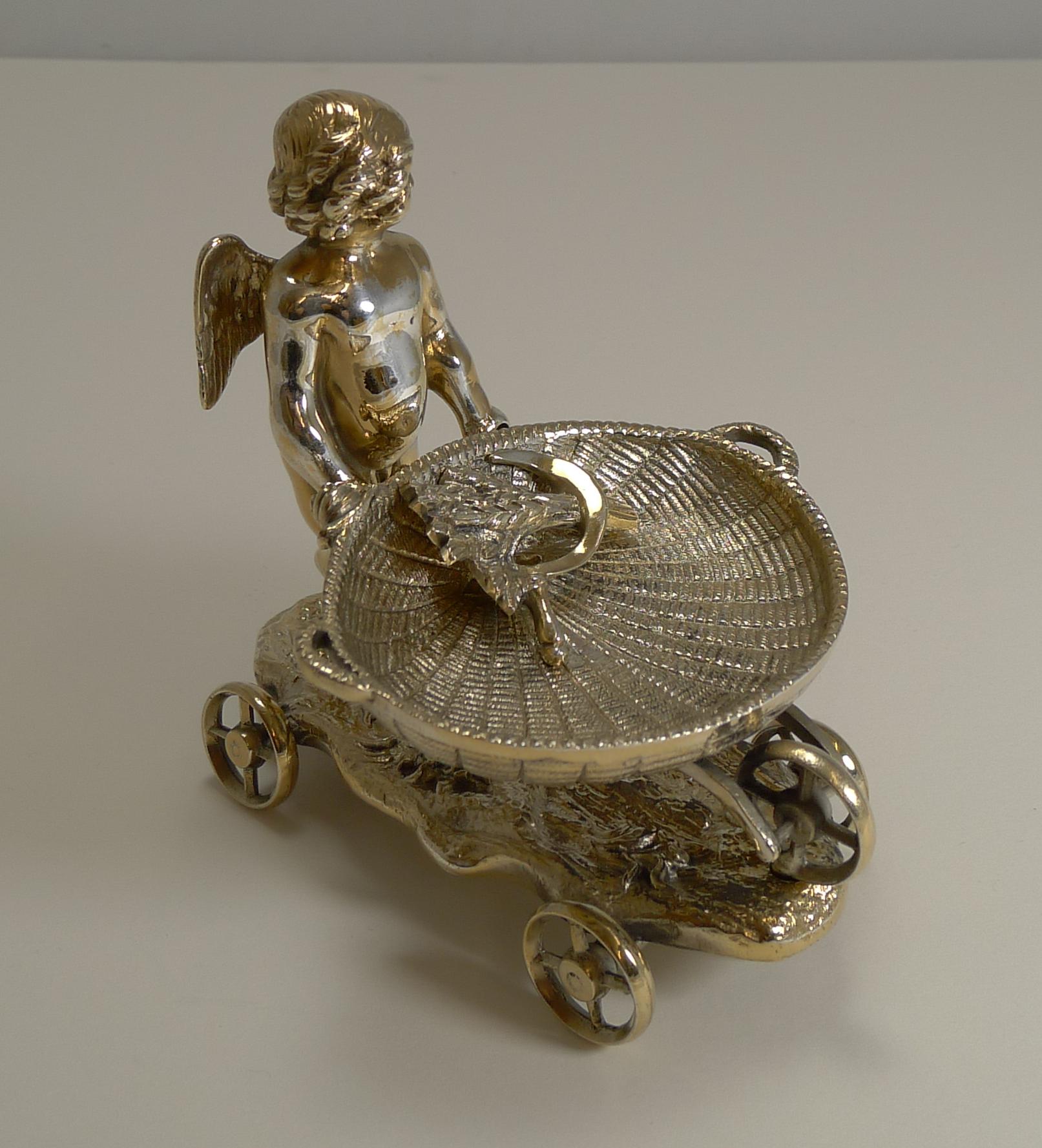 Dating to circa 1890, I haven't had an open salt like this for several years, this Victorian figural silver plated salt is as charming as they get.

The wheels move, to push around the dinner table, the adorable winged cherub is pushing a basket
