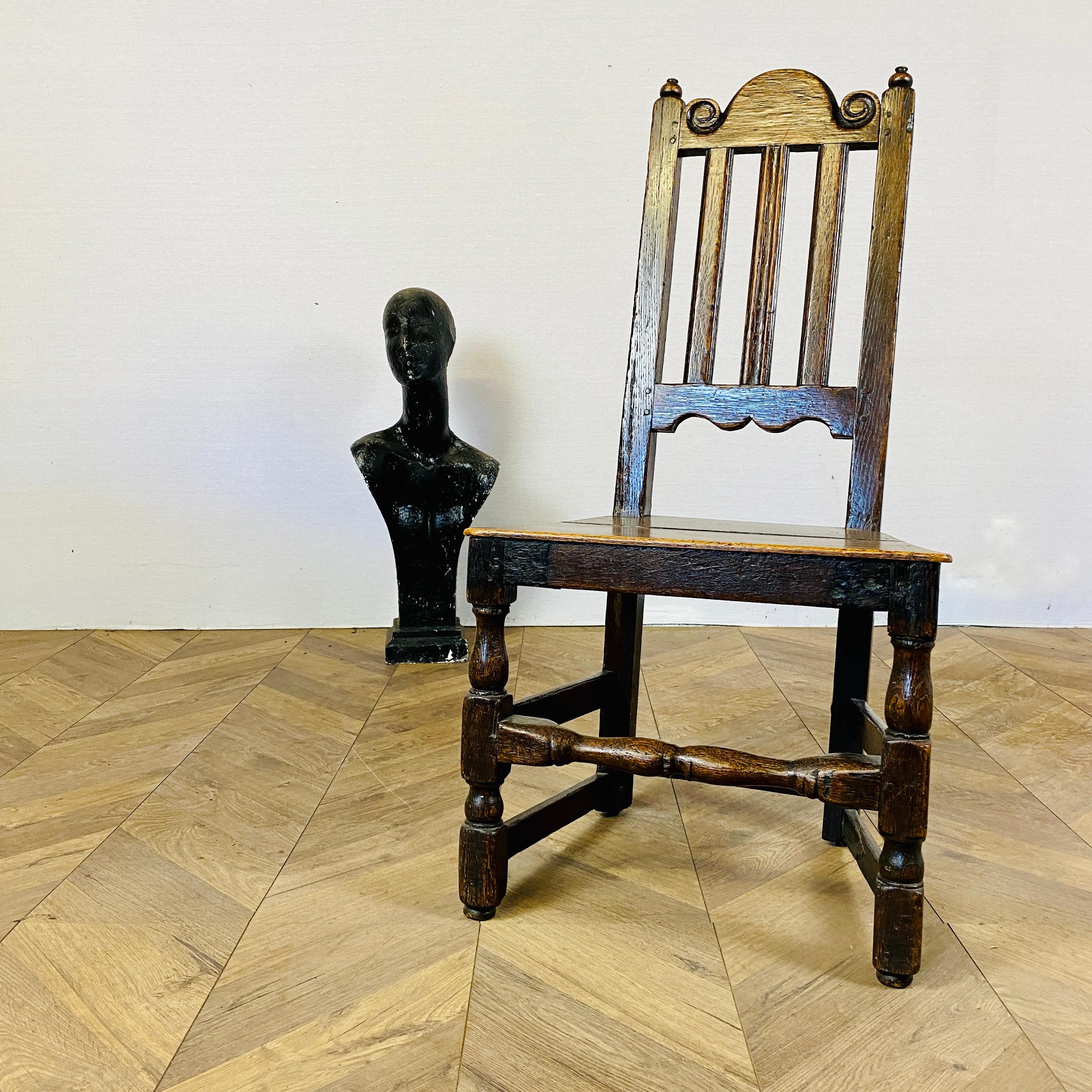 A Simple Antique English 17th Century chair, circa 1660 - 1690

Dating to the reign of Charles II of England, the chair is made from oak, with carved cresting rail over three splats, to a boarded seat and baluster turned under frame.

The chair