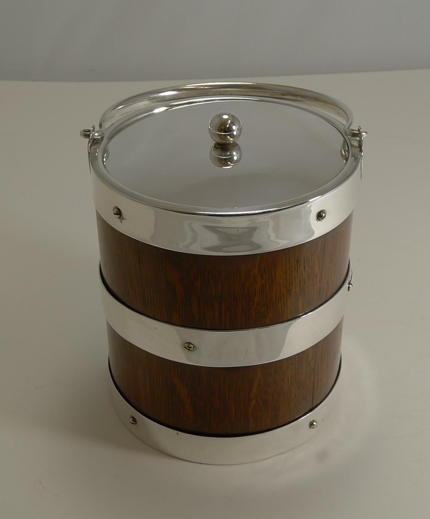 This particular late Victorian biscuit box or barrel lends itself to doubling as an ice bucket due to it's size and straight lines, take a look at the last photograph.

Made from solid English oak the box is mounted with silver plated fittings