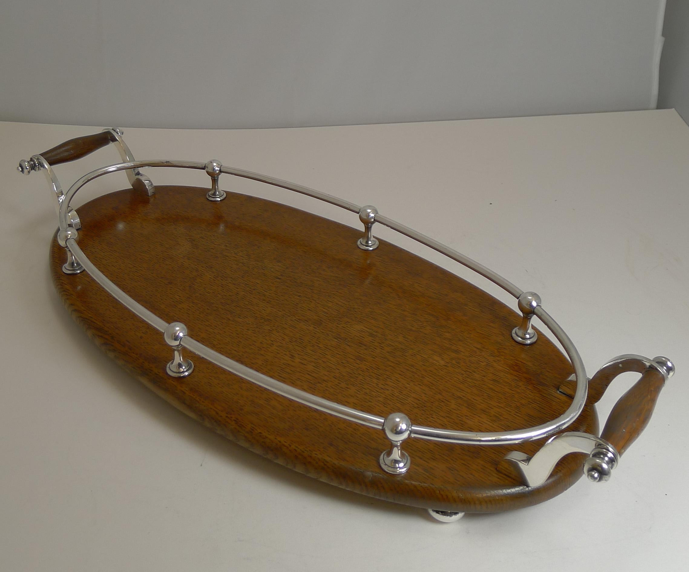 An unusual example of a late Victorian or early Edwardian serving / drinks tray, a smaller size than most and a lovely elegant slim and long oval.

Made from solid English Oak, the fittings are all made from EPNS (electro-plated nickel silver).