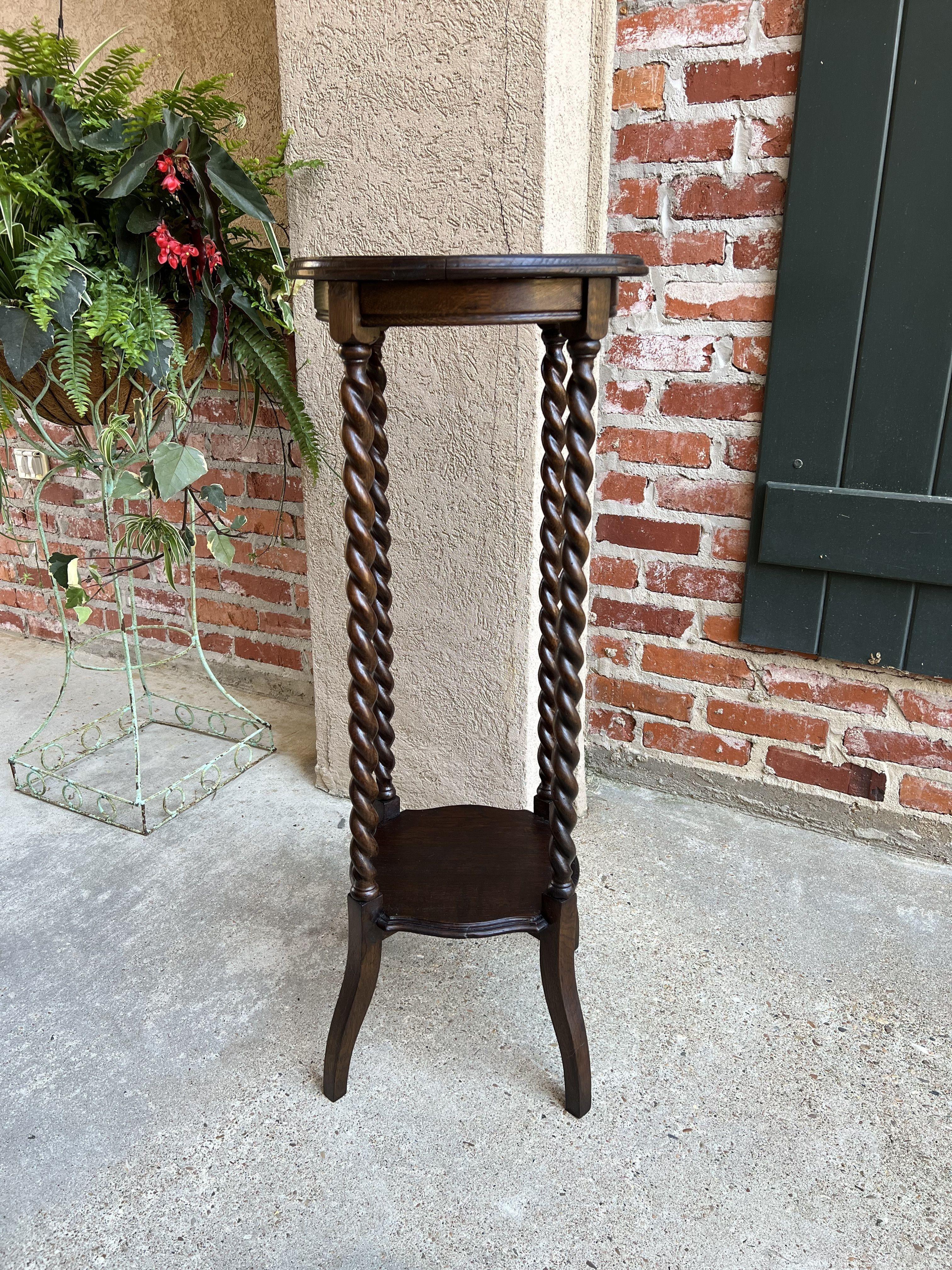 Antique English oak barley twist plant bronze display stand round table Jacobean.

Direct from London, a very versatile antique English display/plant stand.
Traditional British style, with four long barley twist legs. Two levels for display, with